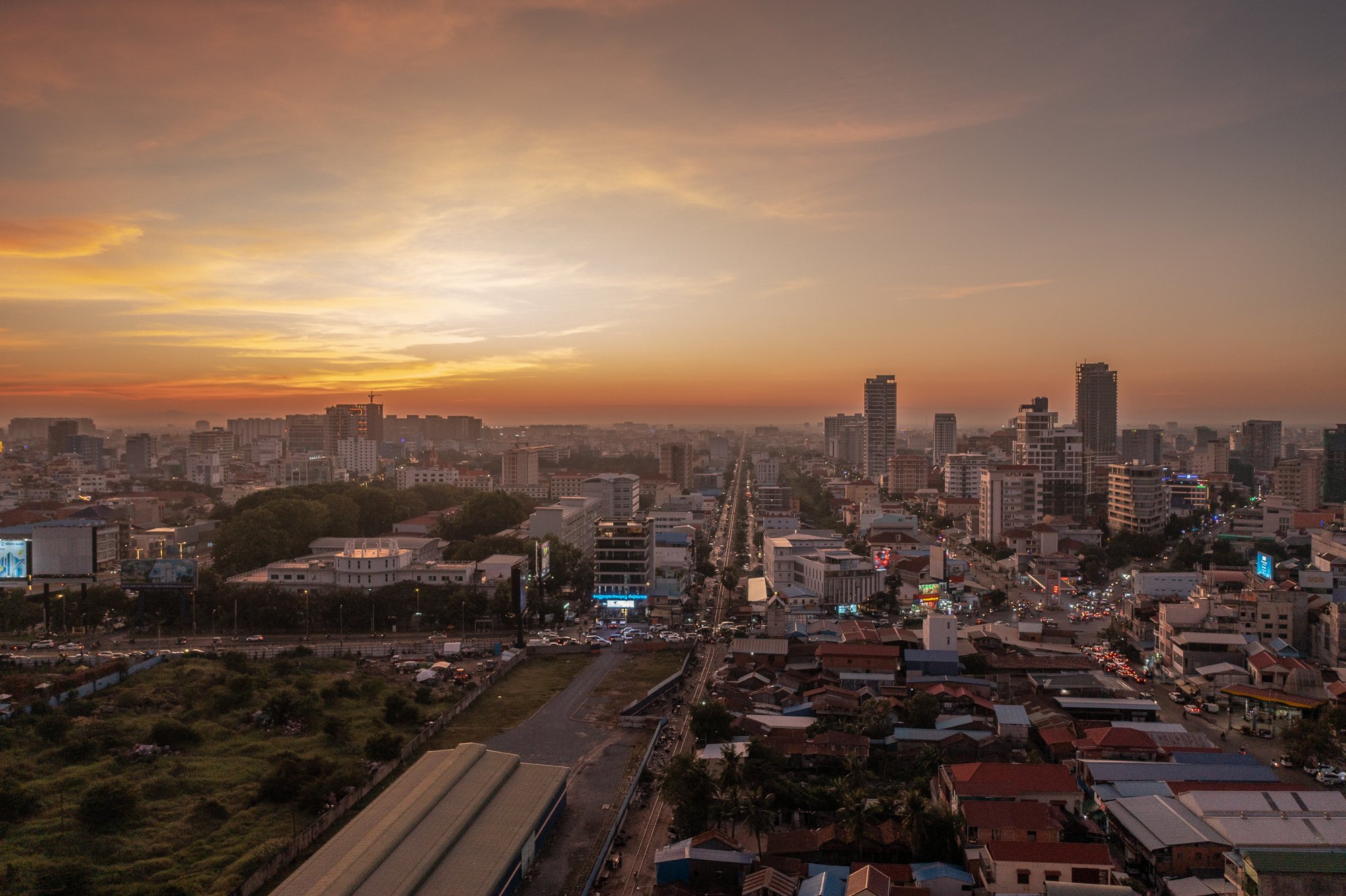A drone photograph over Phnom Penh, looking to the west as the sunsets over the railway tracks.