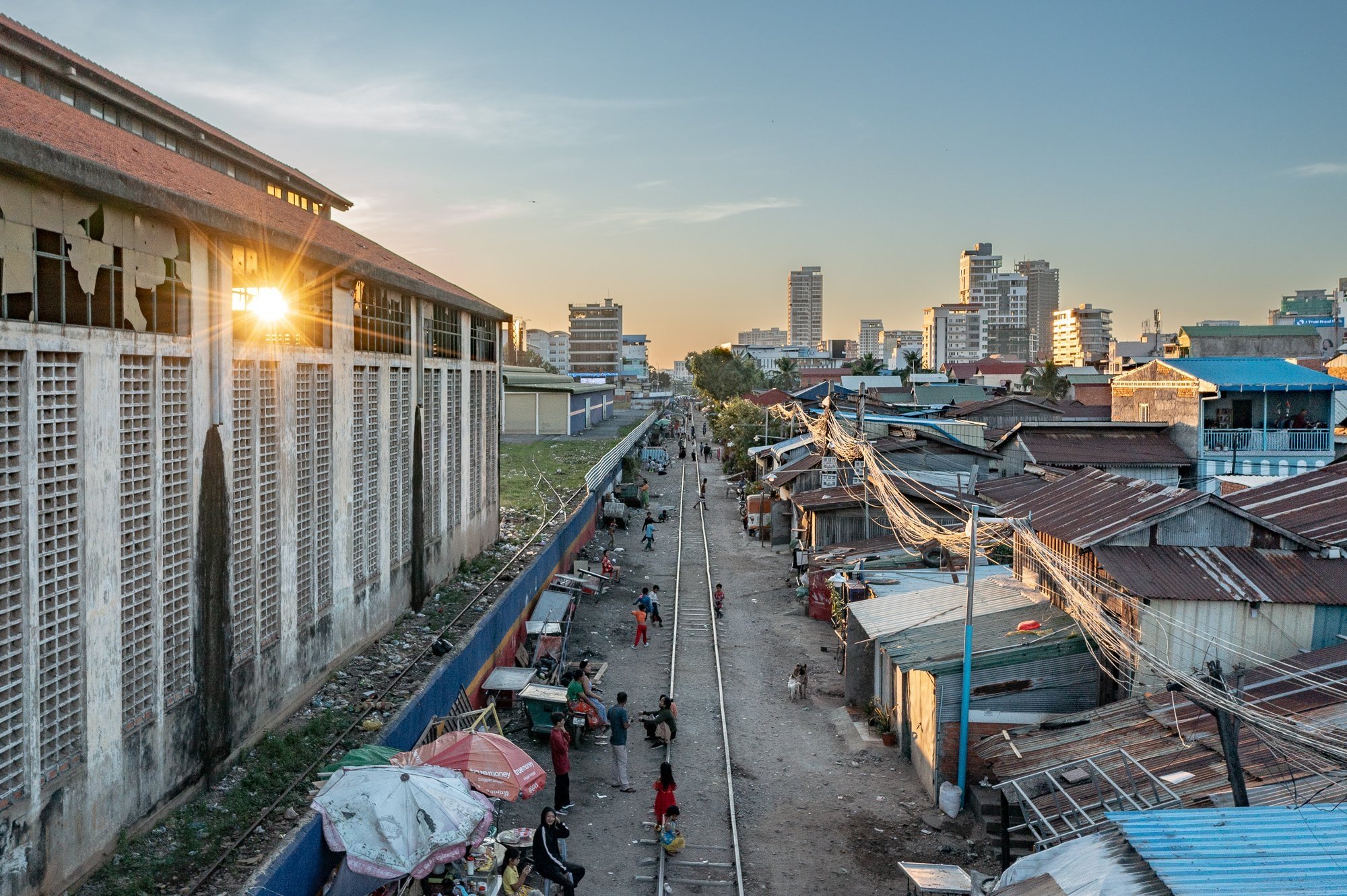 A drone photograph of sunburst is seen through the railway building looking to the west down the tracks at sunset, Phnom Penh, Cambodia 