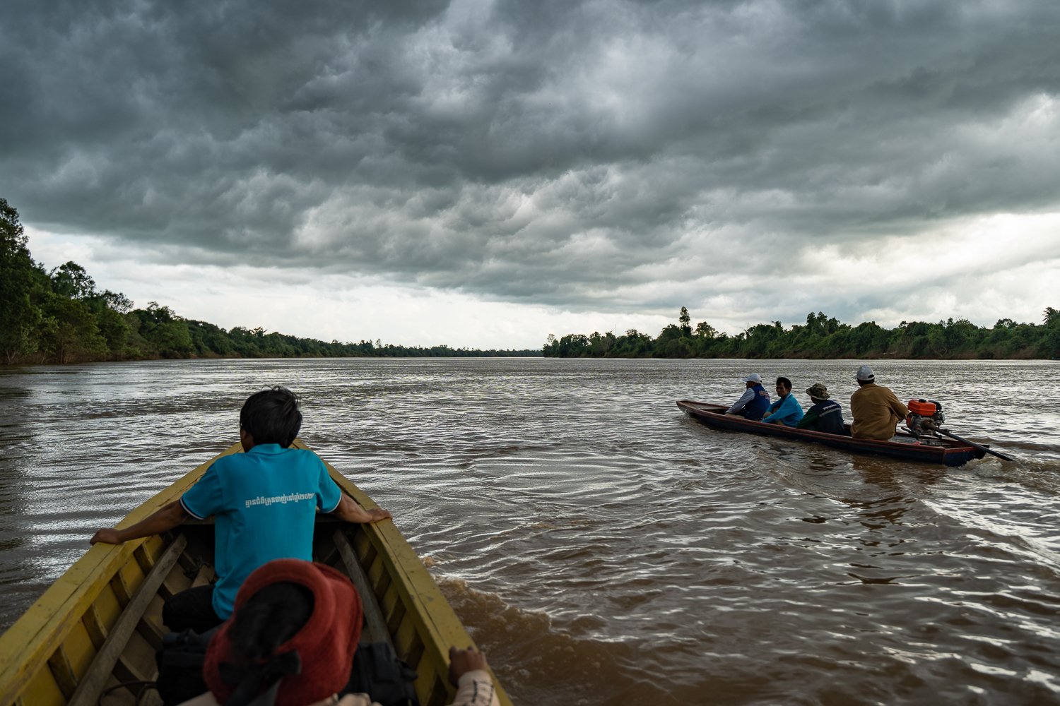 Sophal and his team return home on boats after a community visit to a remote village