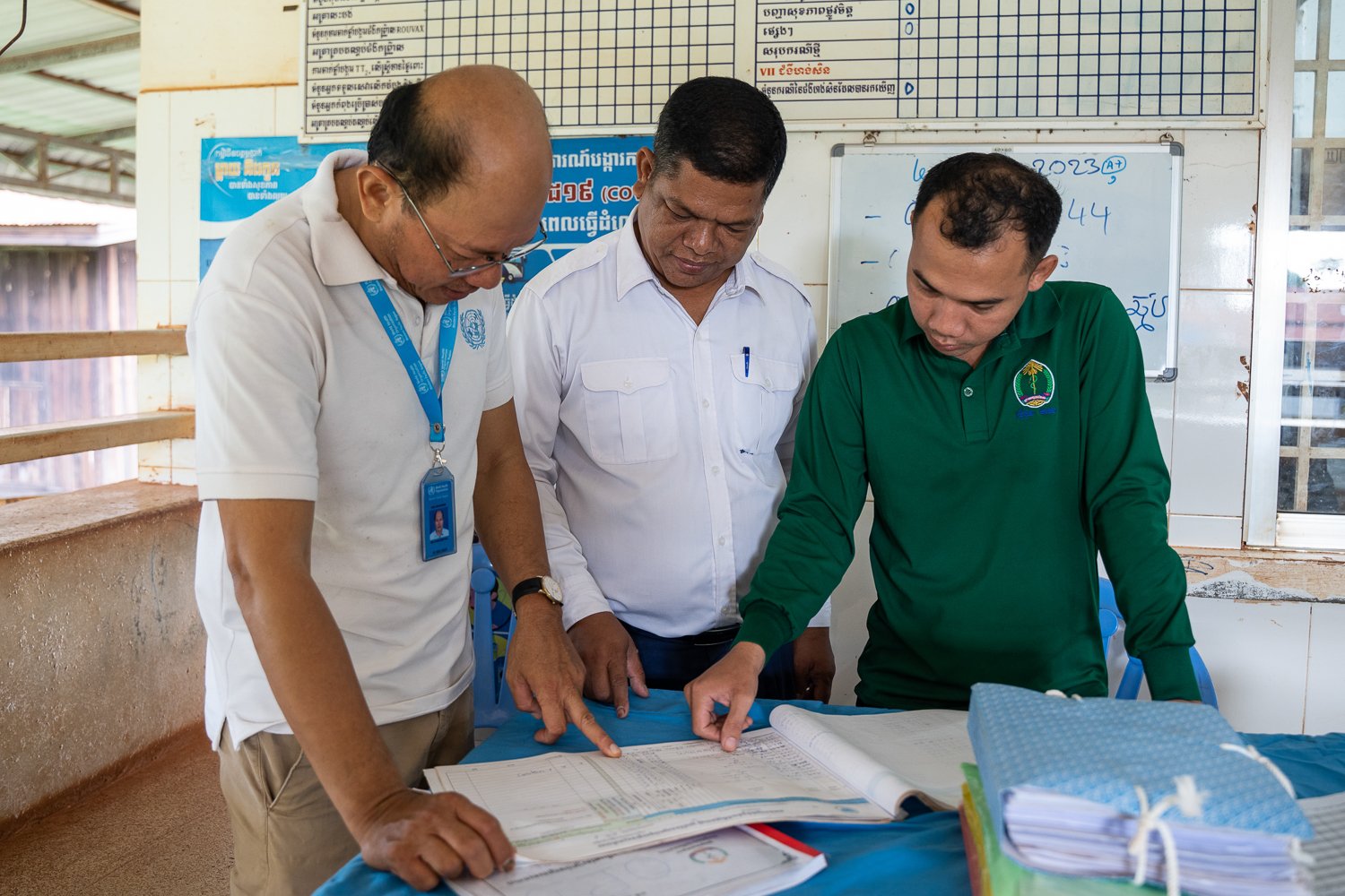 Sophal and health center staff check malaria information at Siem Pang Health Center