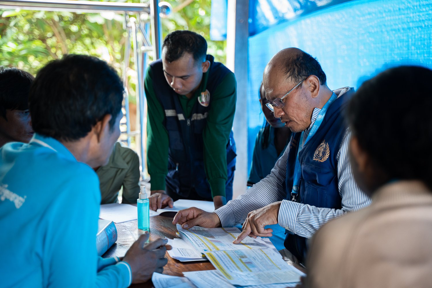 Sophal reviews malaria record with his team in a remote village