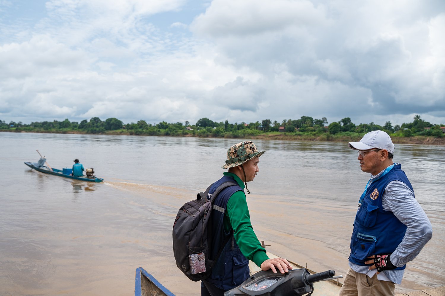 Sophal in discussion with a WHO team member on a small ferry to a remote village where they work