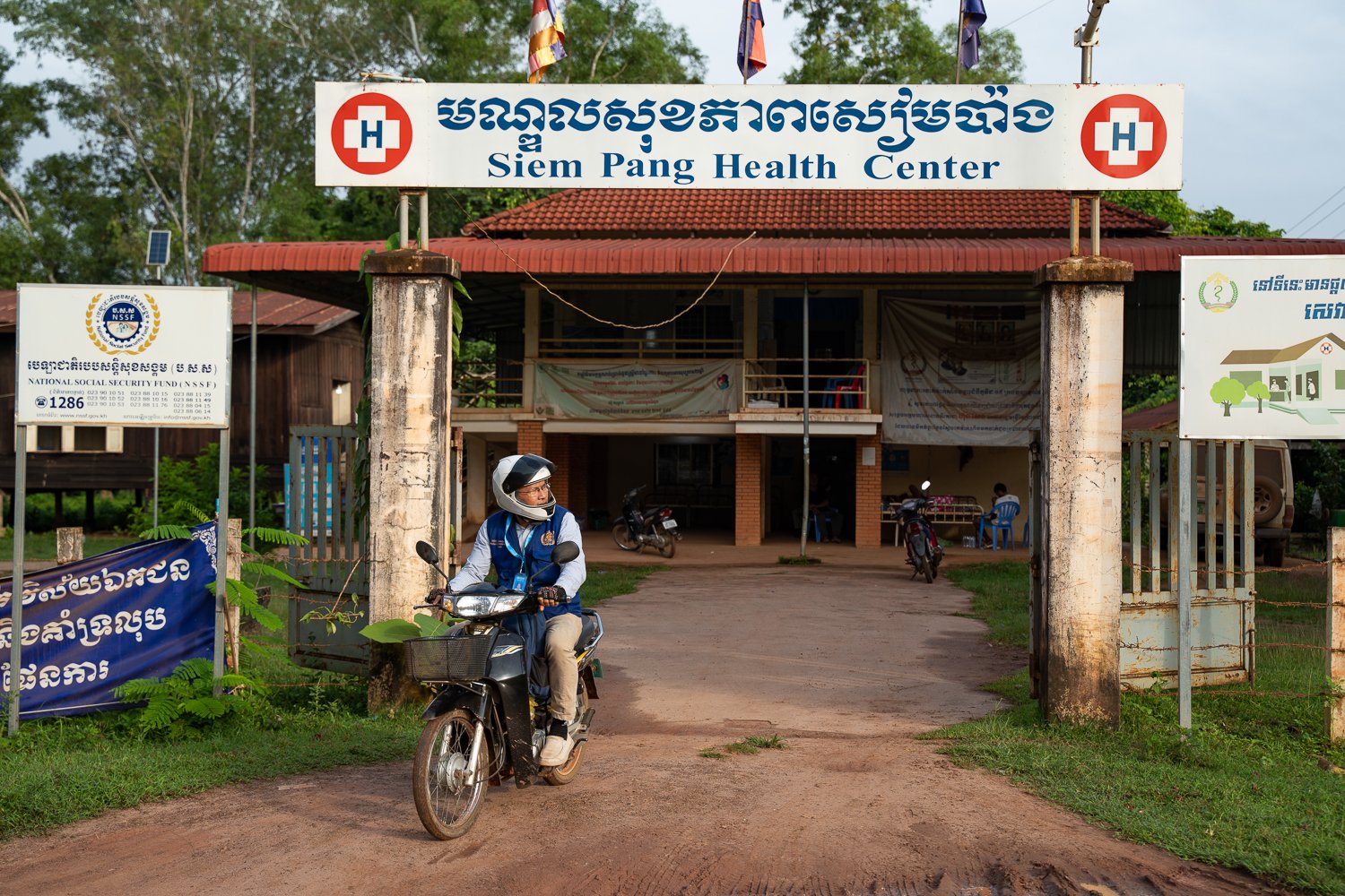 Sophal drives out of Siem Pang Health Center on his motorbike to go on a community visit