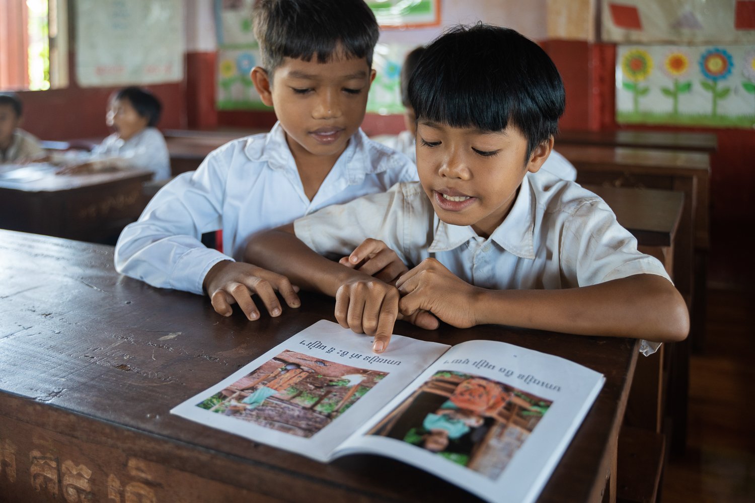 Cheat Yut (L) and Vang Chiva (R) read a book in their indigenous language in class, Ratanikiri Province, Cambodia