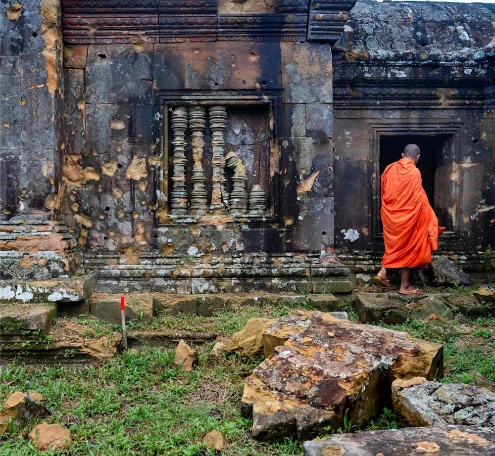 Abbot Sun Sang amid shell damage at Gopura I, Preah Vihear temple, Cambodia