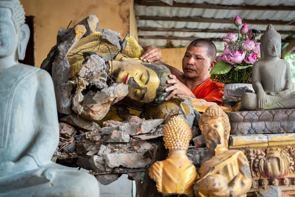 Abbot Sun Sang with broken Buddha statues at Wat Keo Sekha Kiri Svarak, Preah Vihear