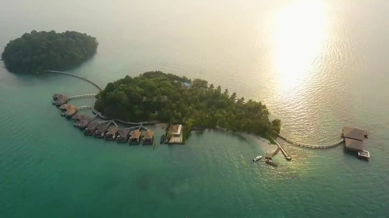 Aerial view of the overwater villas on Song Saa Private Island with the sun on the water, Koh Rong Archipelago, Cambodia