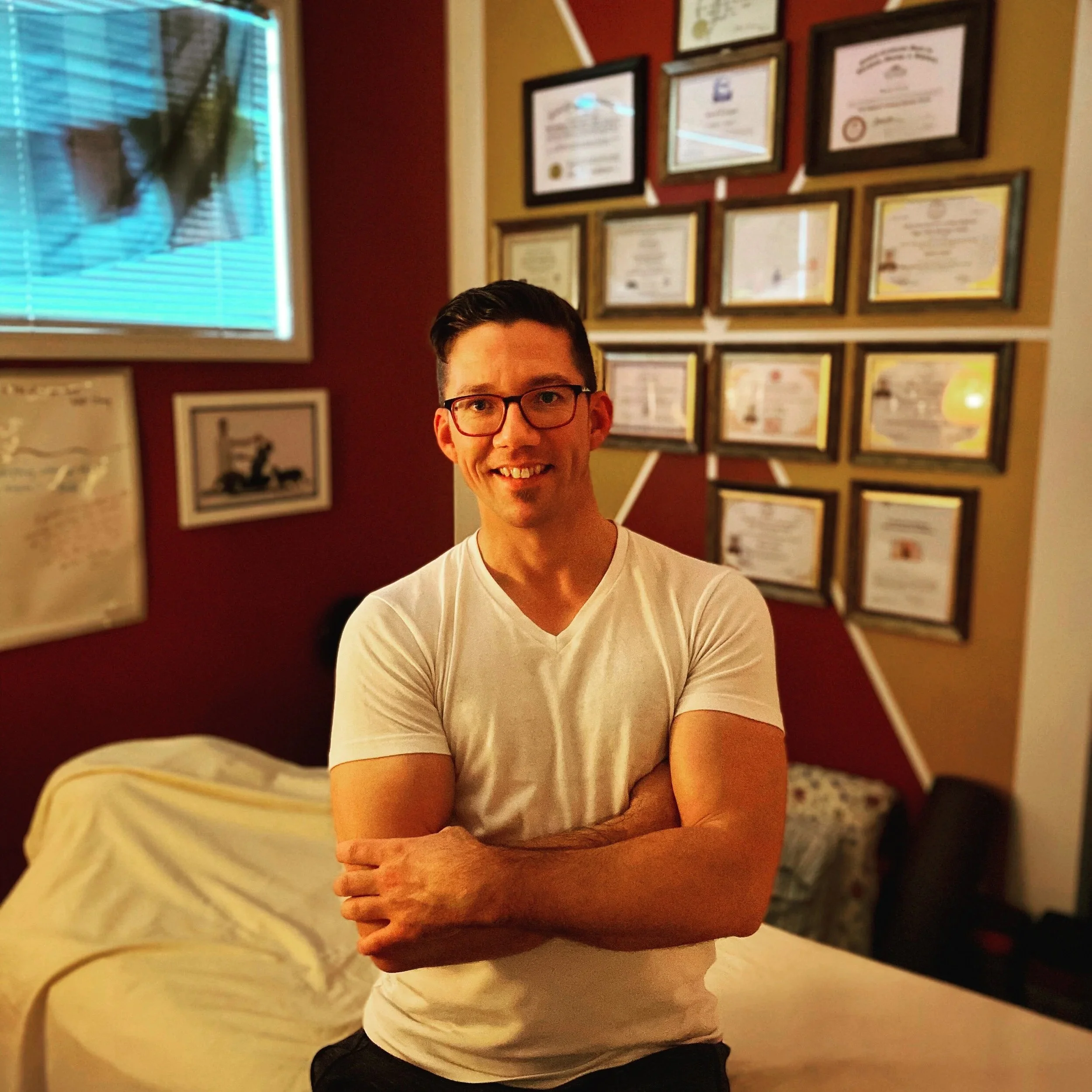 Kevin Lynch Thai massage teacher and NCBTMB-approved continuing education provider with certification wall at Lynch Advanced Bodyworks