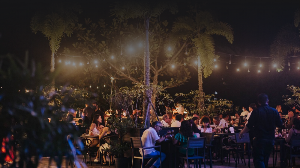 Outdoor dining tables under string lights at 1918 Heritage Bar