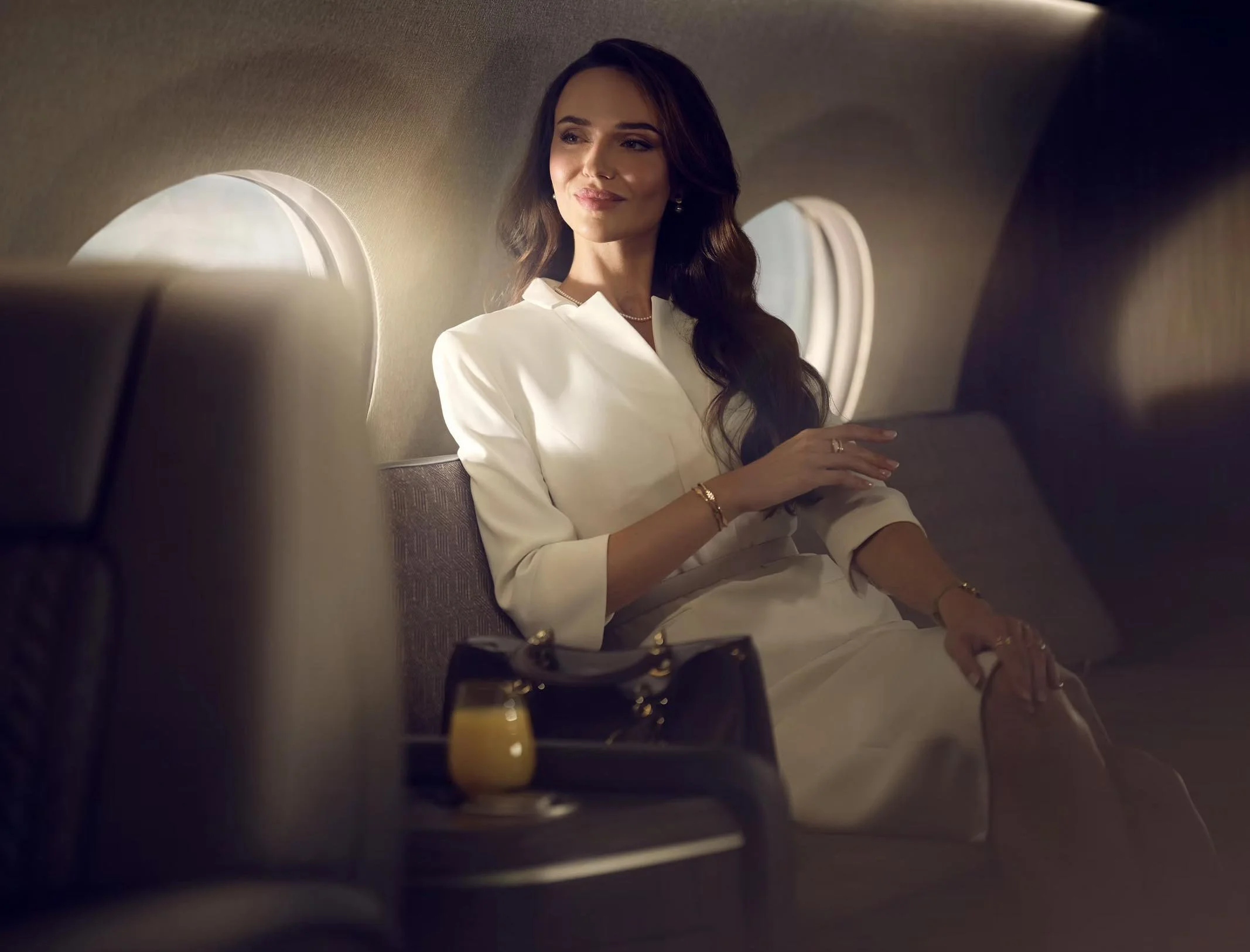 Aviation lifestyle image of a female business women onboard a private jet by luxury lifestyle photographer Jon Enoch