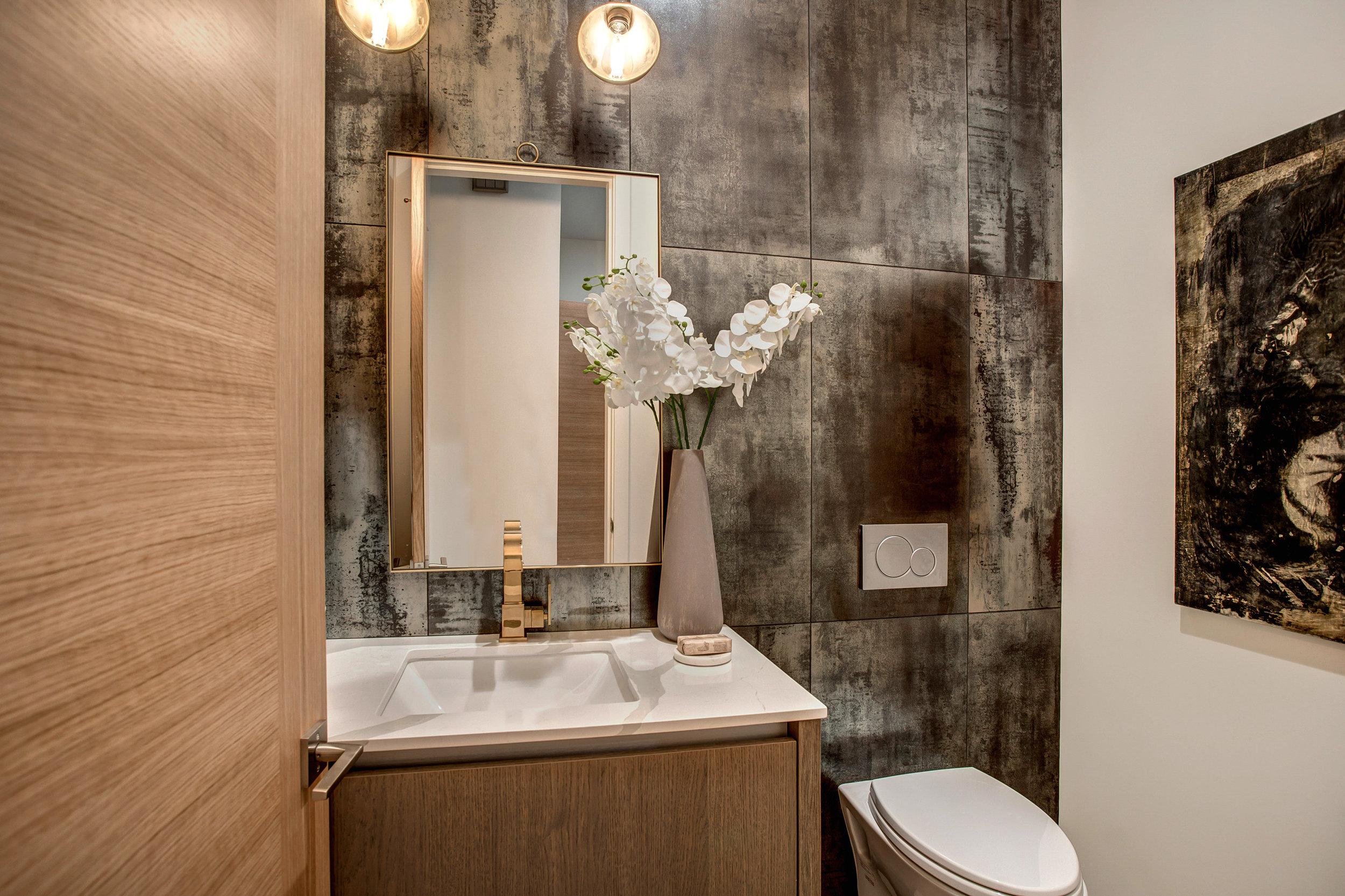Powder room featuring floor to ceiling Copper Corten metallic tile accent wall with Restoration Hardware Aged Brass faucet and bath hardware.