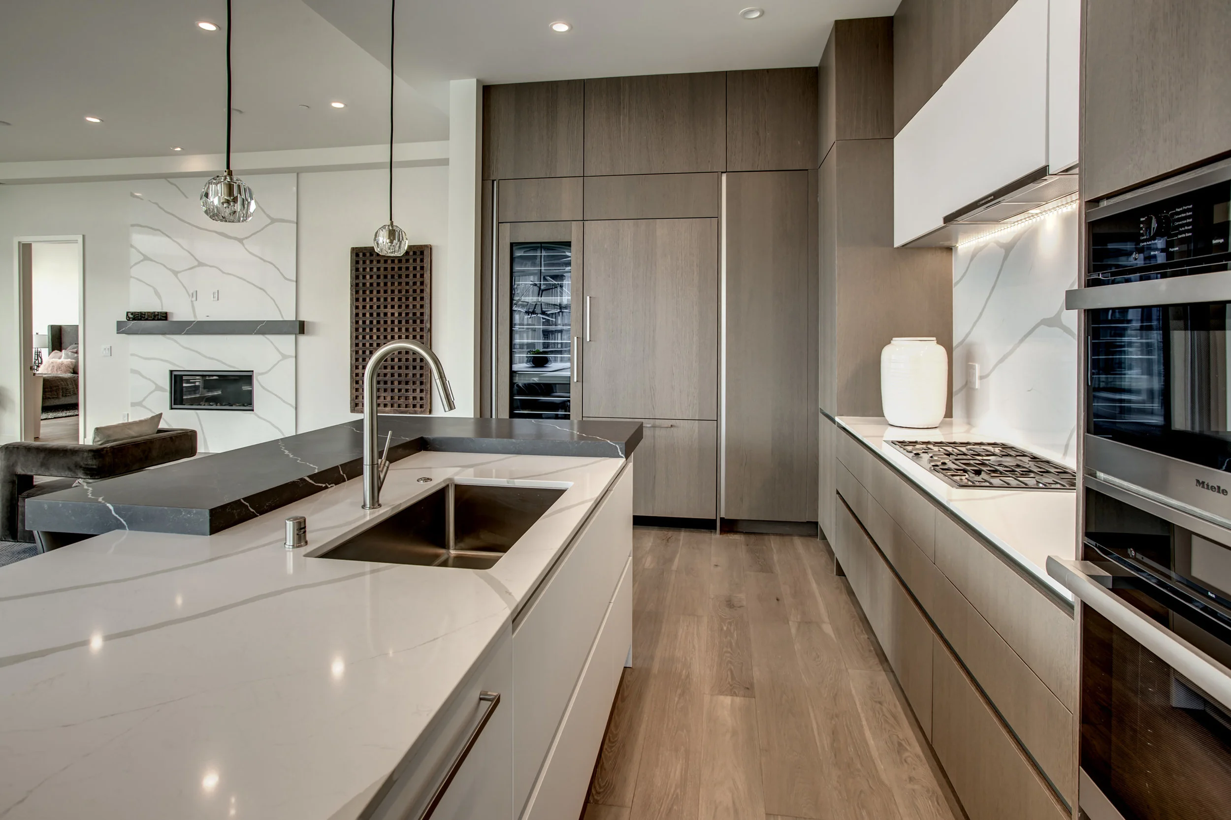 The kitchen is equipped with Miele appliances and includes an espresso maker, wine tower, and three ovens.