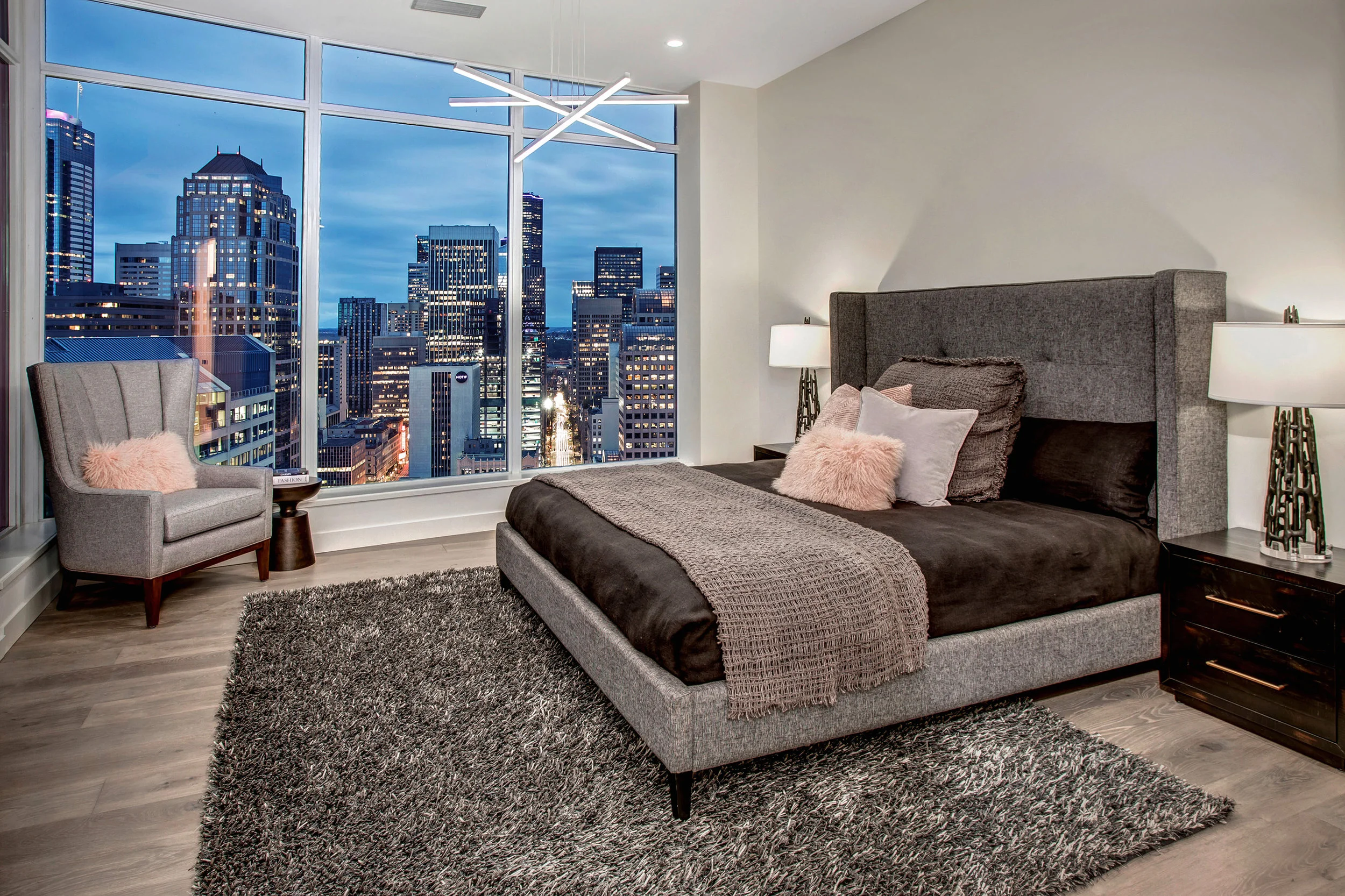 Master bedroom at dusk with glittering city views.