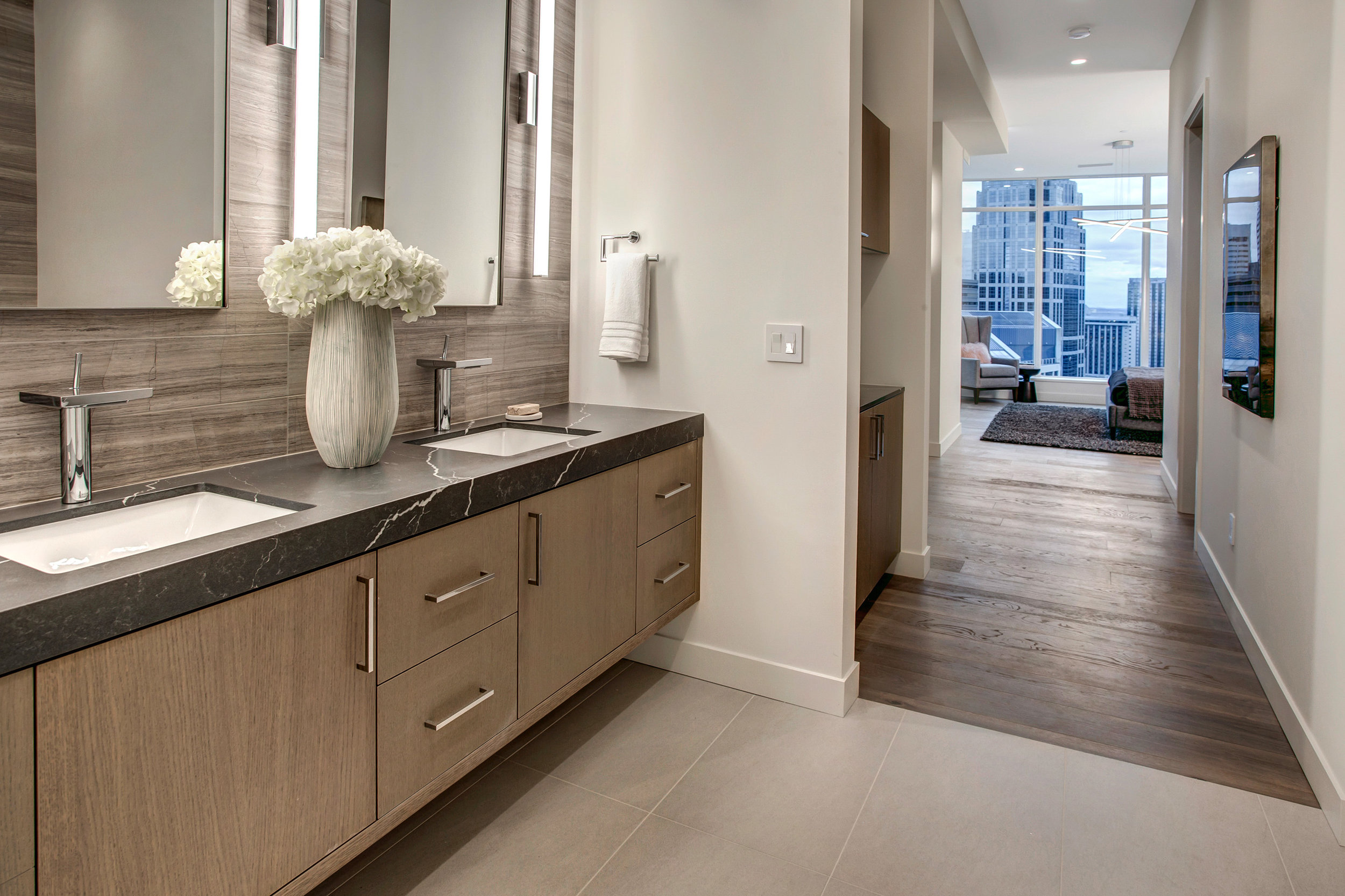 Master suite includes a built-in coffee nook, large walk-in closet, dual sink vanity with Hansgrohe Axor waterfall faucets, honed finish Quartz countertop, and Marble tile accent wall.