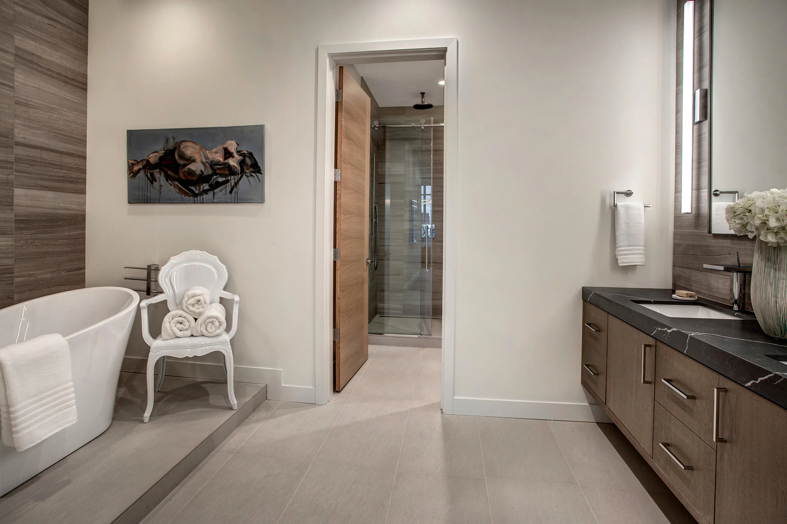 Freestanding luxurious bathtub with floor to ceiling Marble tile accent wall and Nameek’s luxury tub filler faucet and shower head.