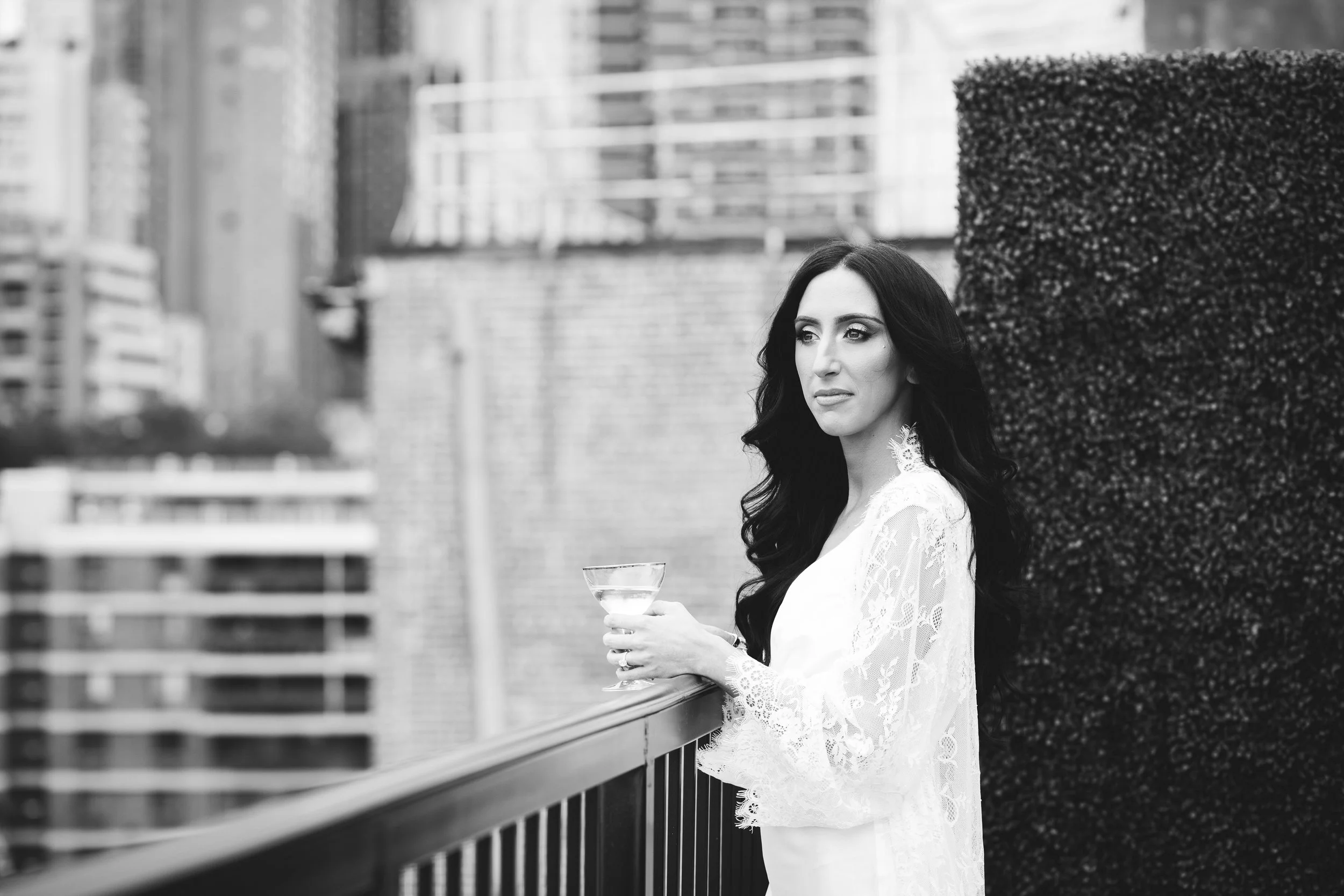 Bride looking over a city balcony