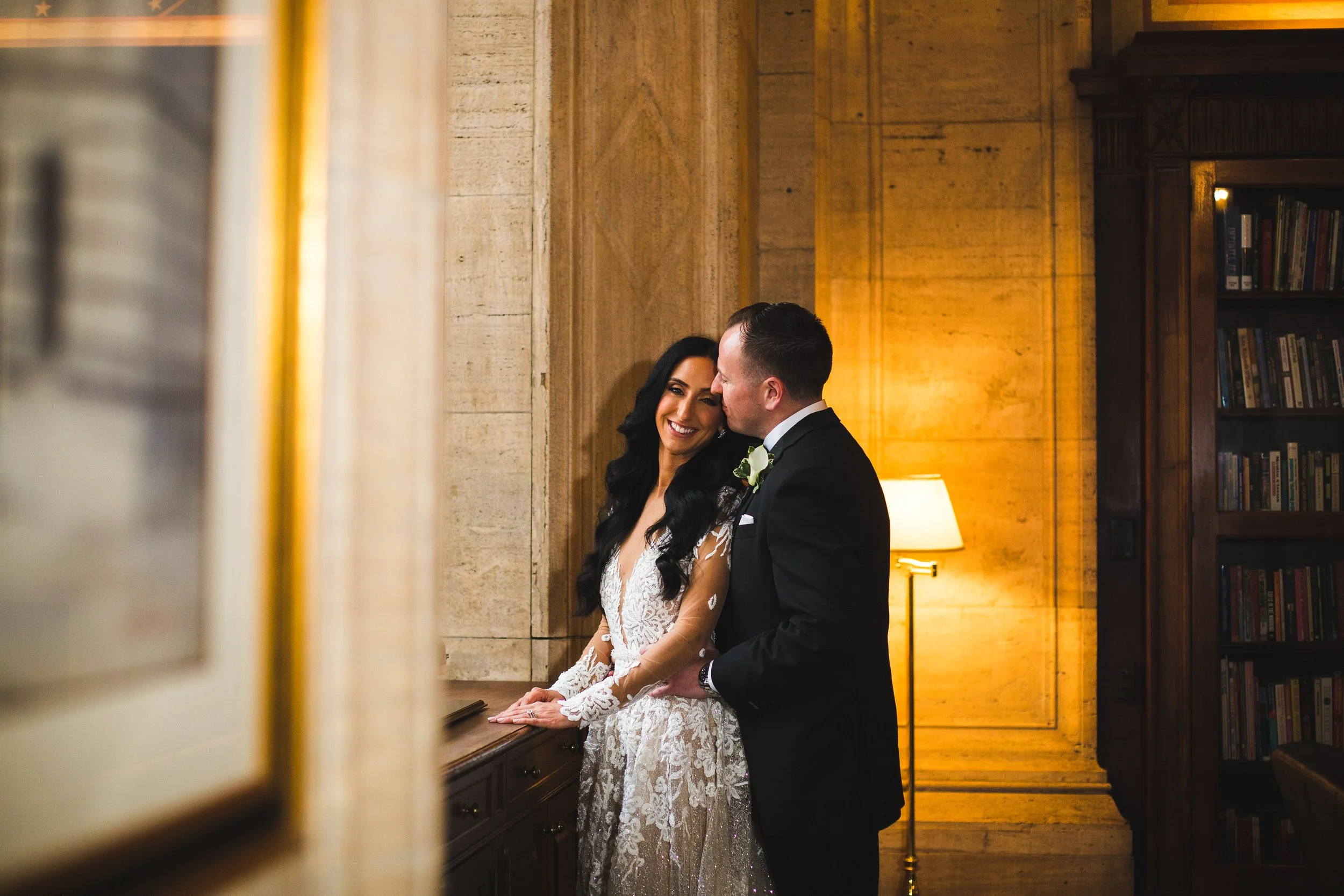 Bride and groom standing by the window and looking at each other lovingly