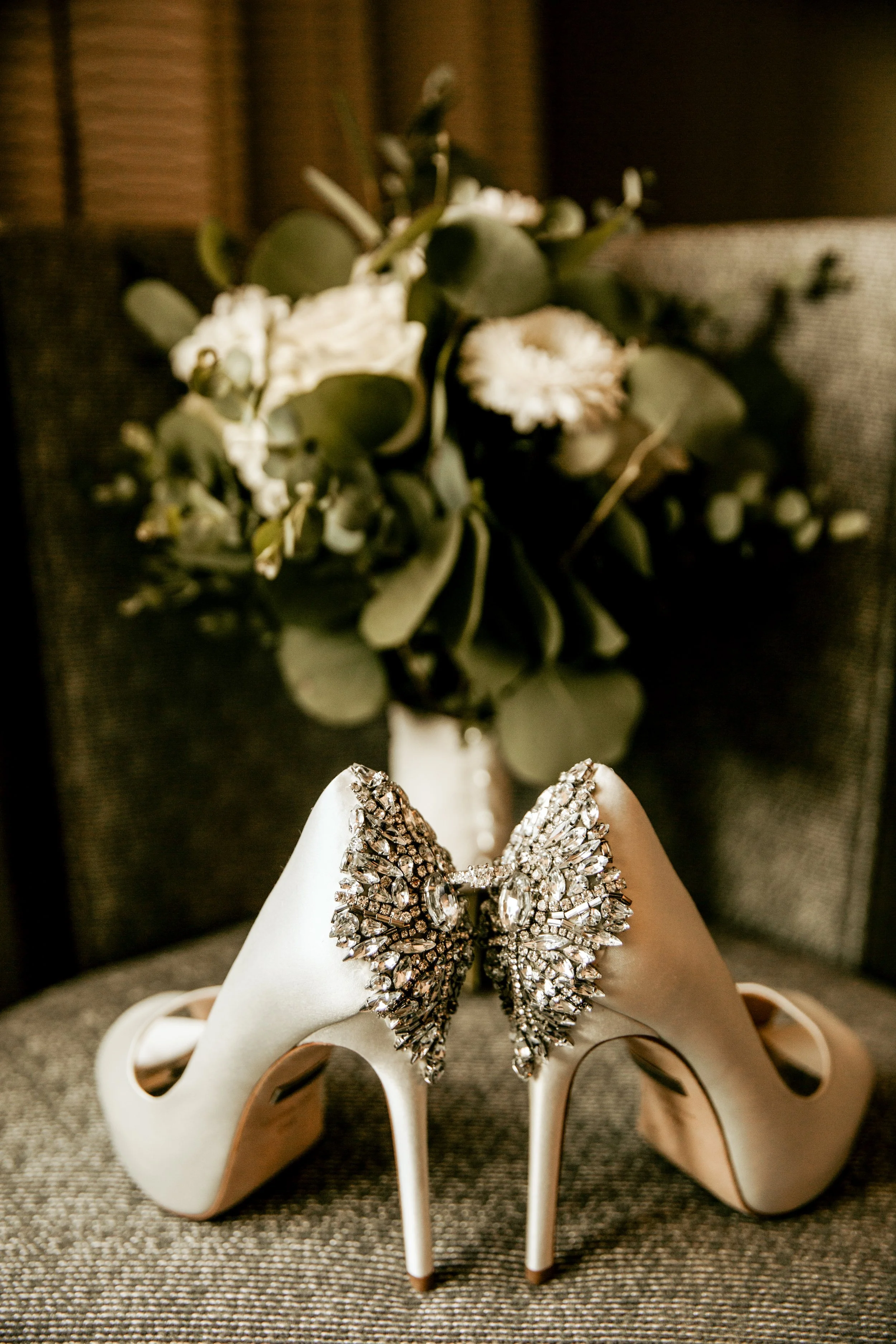 Bridal high heel shoes and flower bouquet on a chair