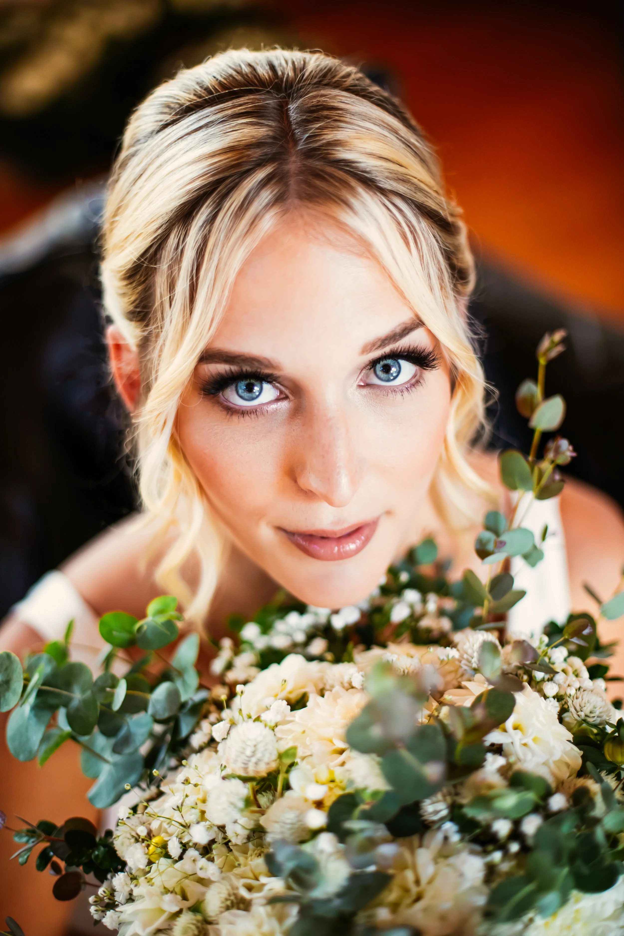Bride looking up at the camera with her flower bouquet