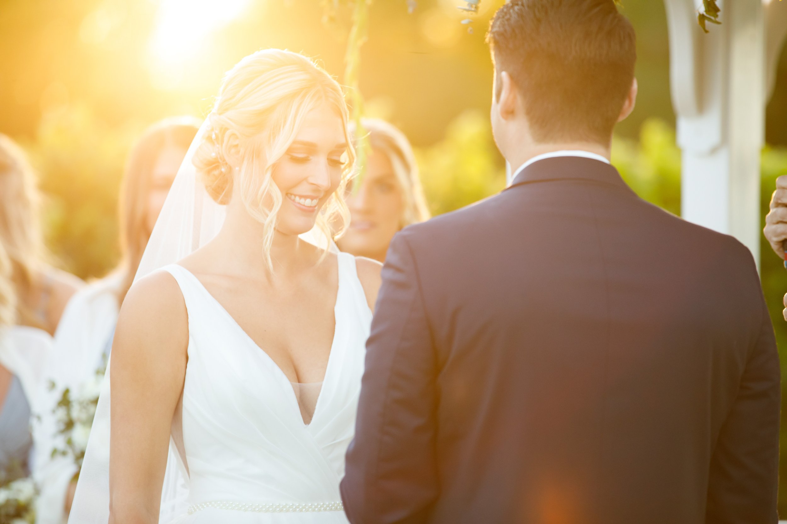 Bride in the sunshine at the altar at her outdoor wedding ceremony