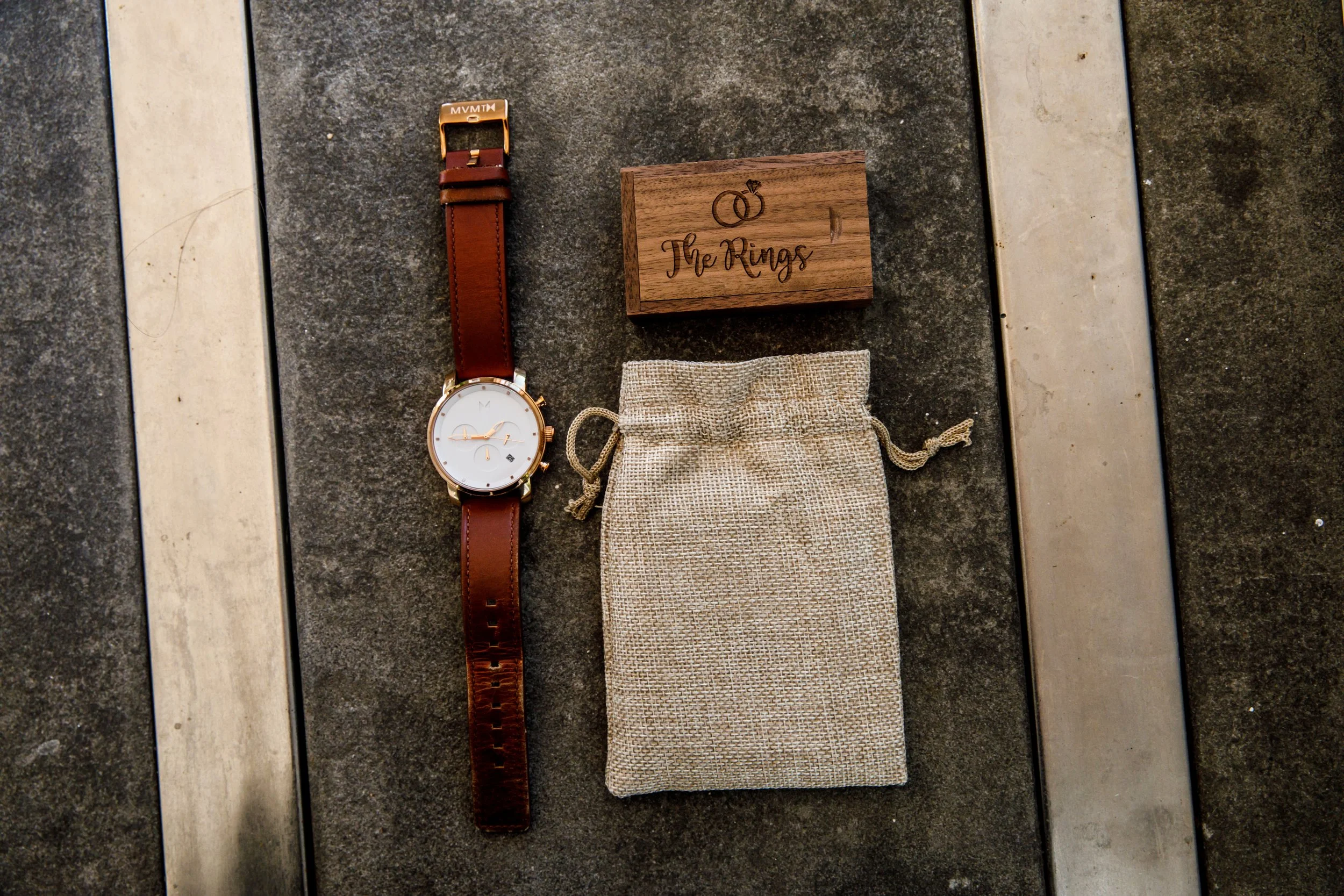 Groom's wedding details including his watch, wedding ring, ring box