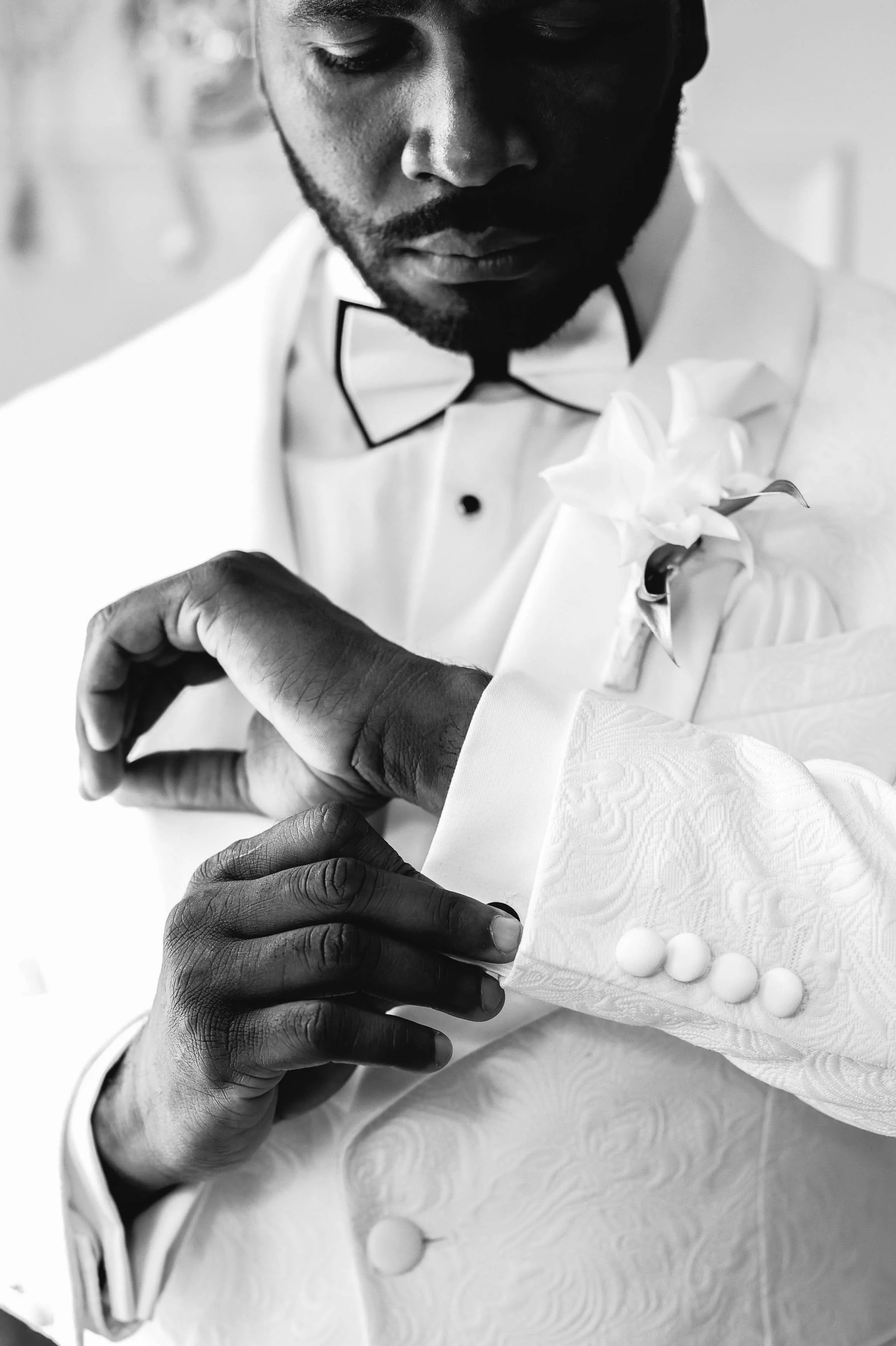 Groom fixing his sleeves and cuff links