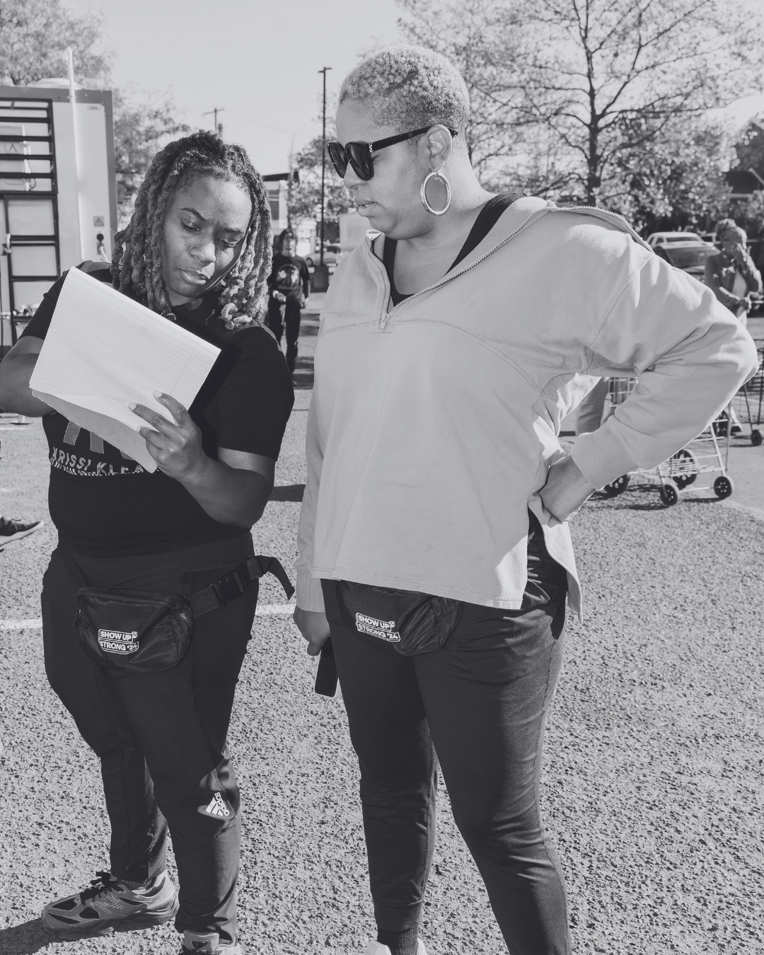 Two people standing together reviewing event checklist in an outdoor setting