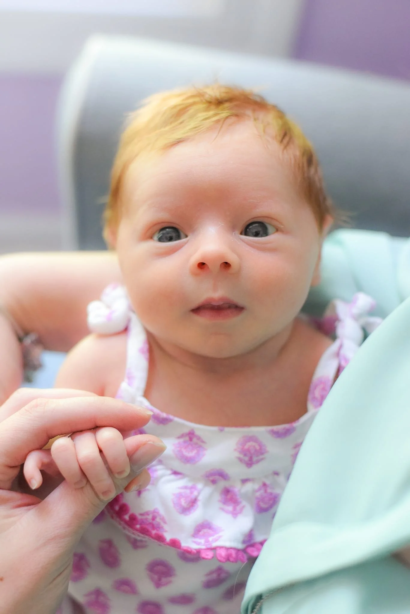 Overhead image of newborn, cradled in her mother’s arms