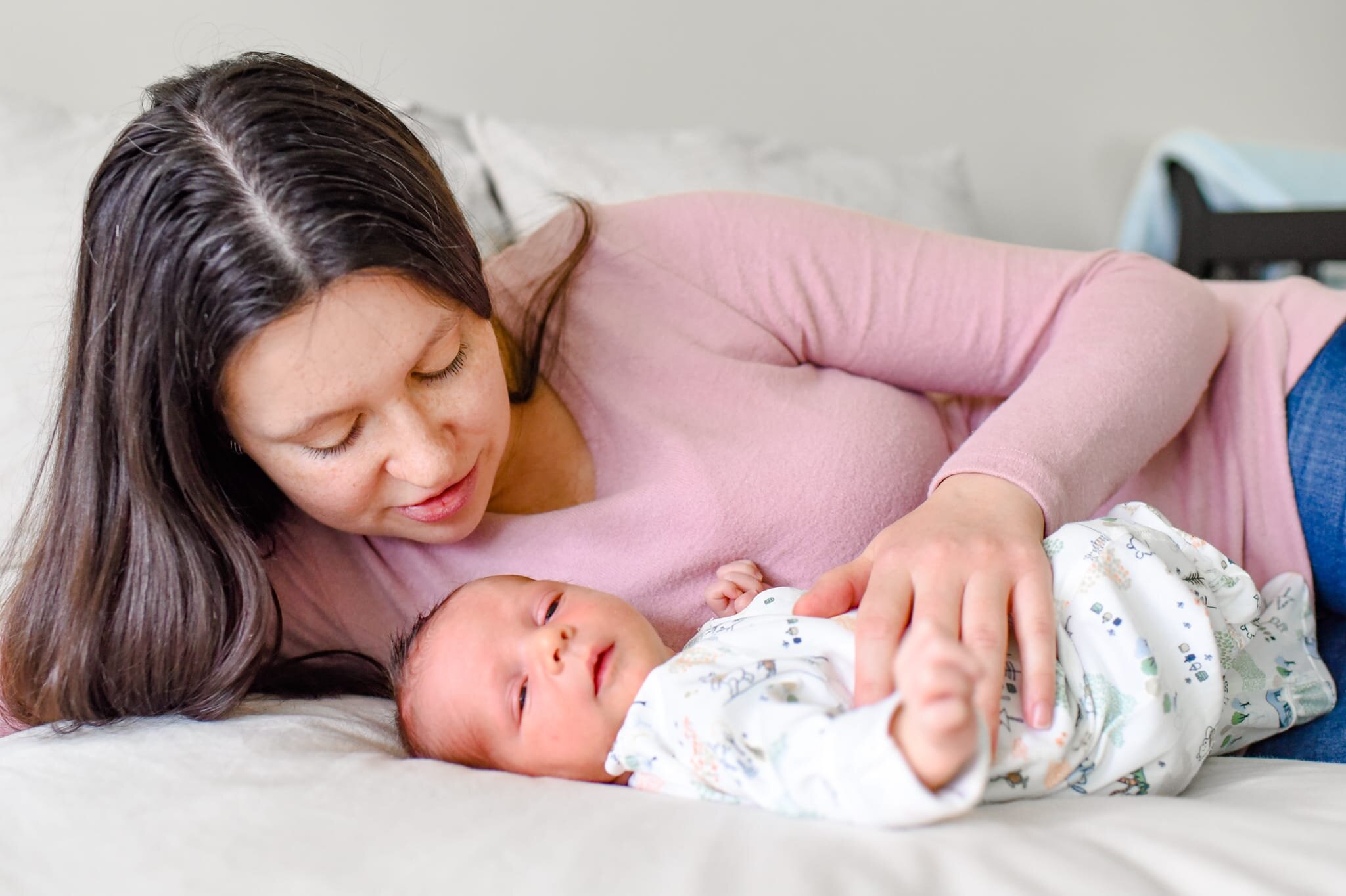 Rockville Maryland Newborn Photographer - mom laying on bed with baby