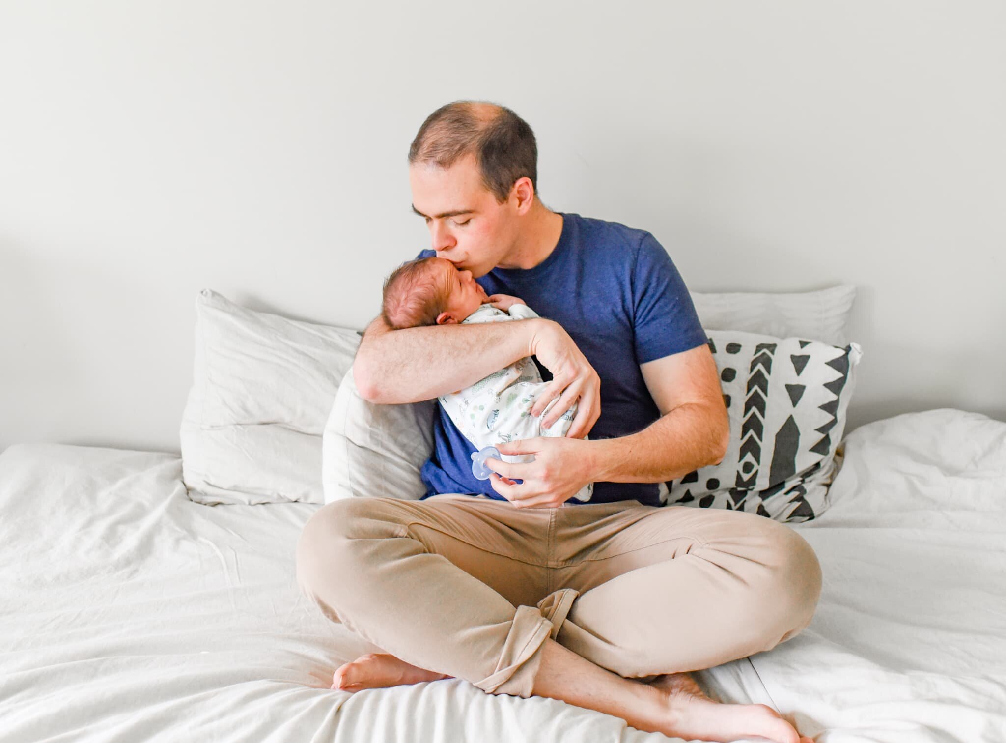 Rockville Maryland Newborn Photographer - dad sitting on bed with baby