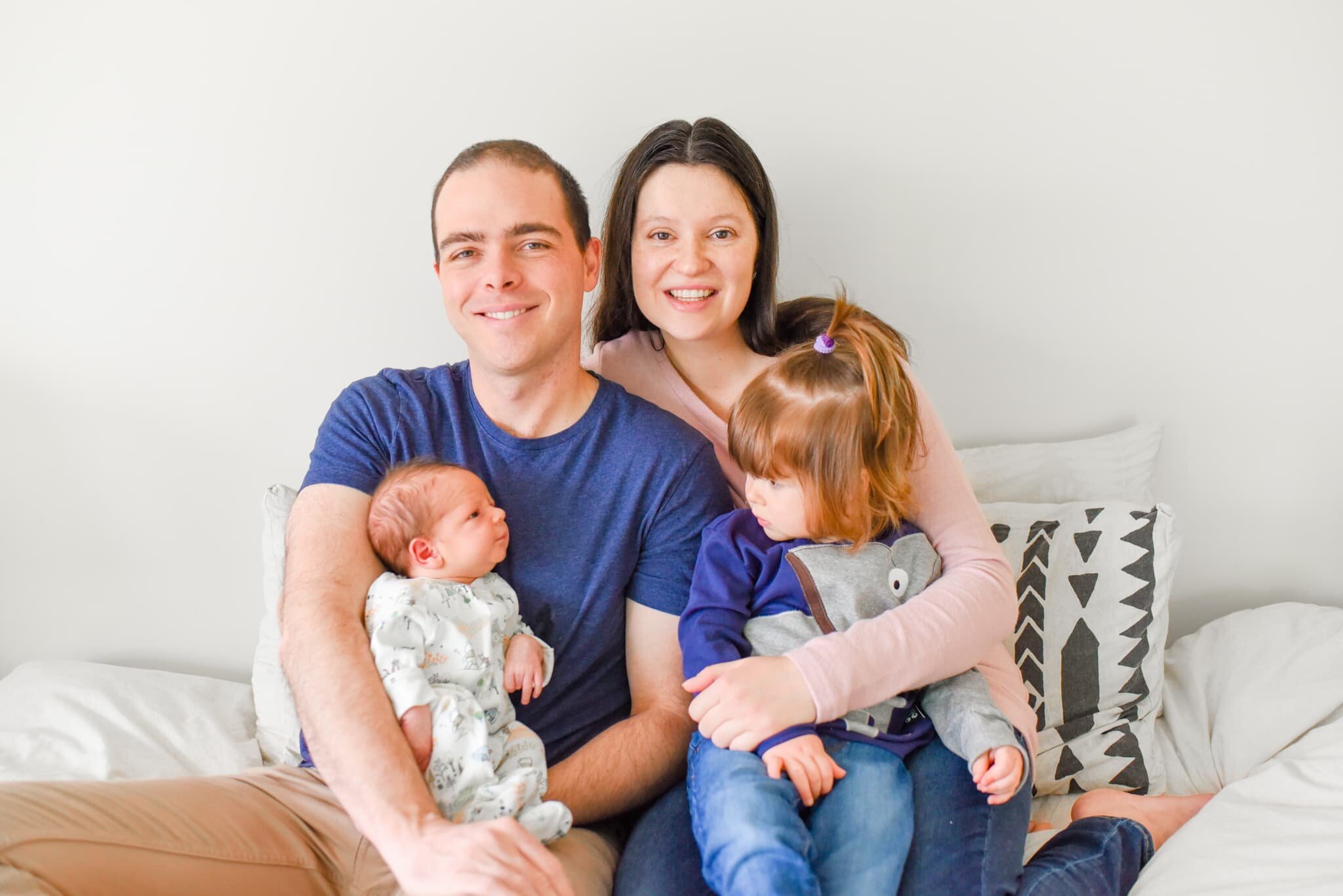 Rockville Maryland Newborn Photographer - family on bed, baby and sibling looking at each other