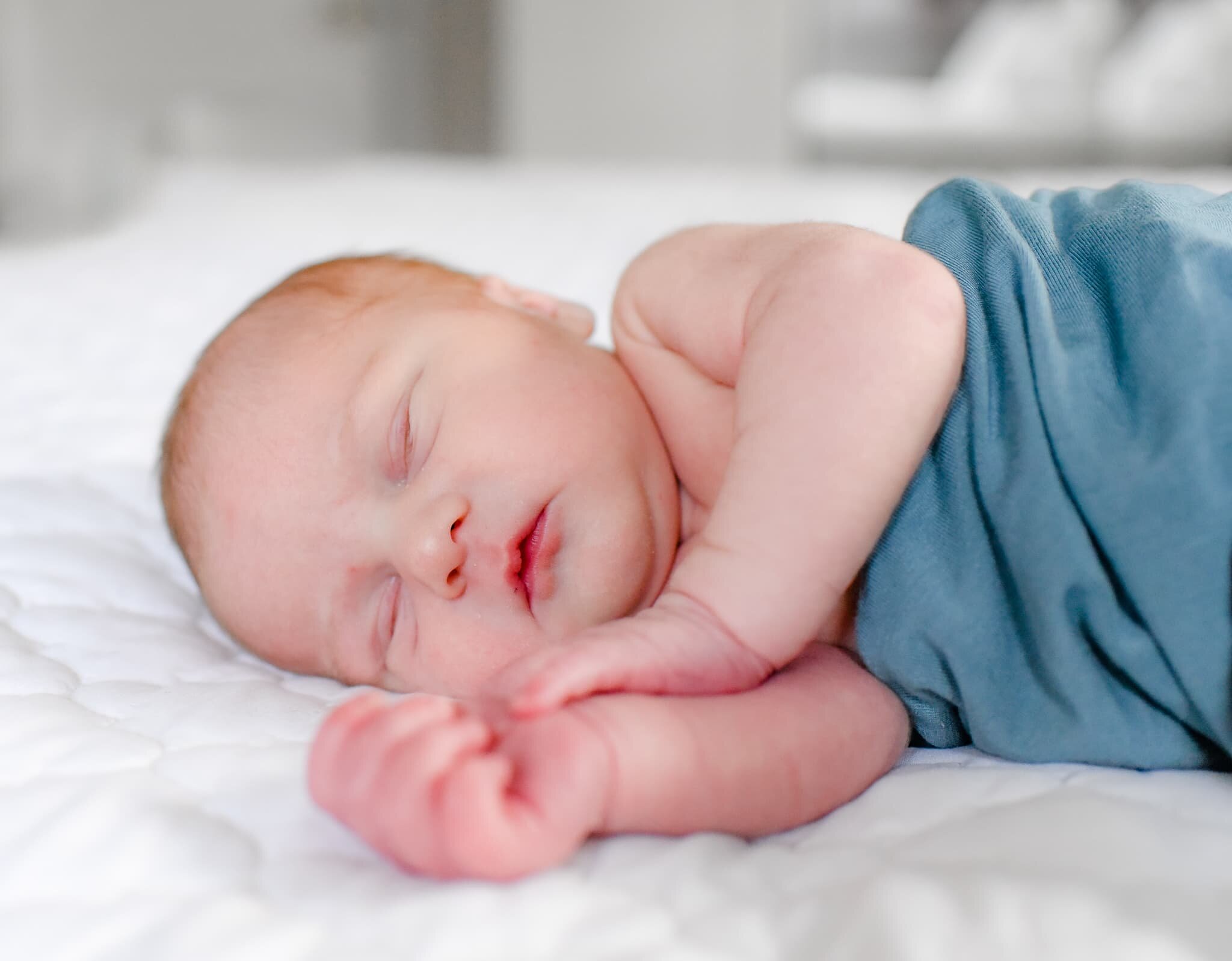 Silver Spring Maryland Newborn Photoshoot - baby curled up on the bed