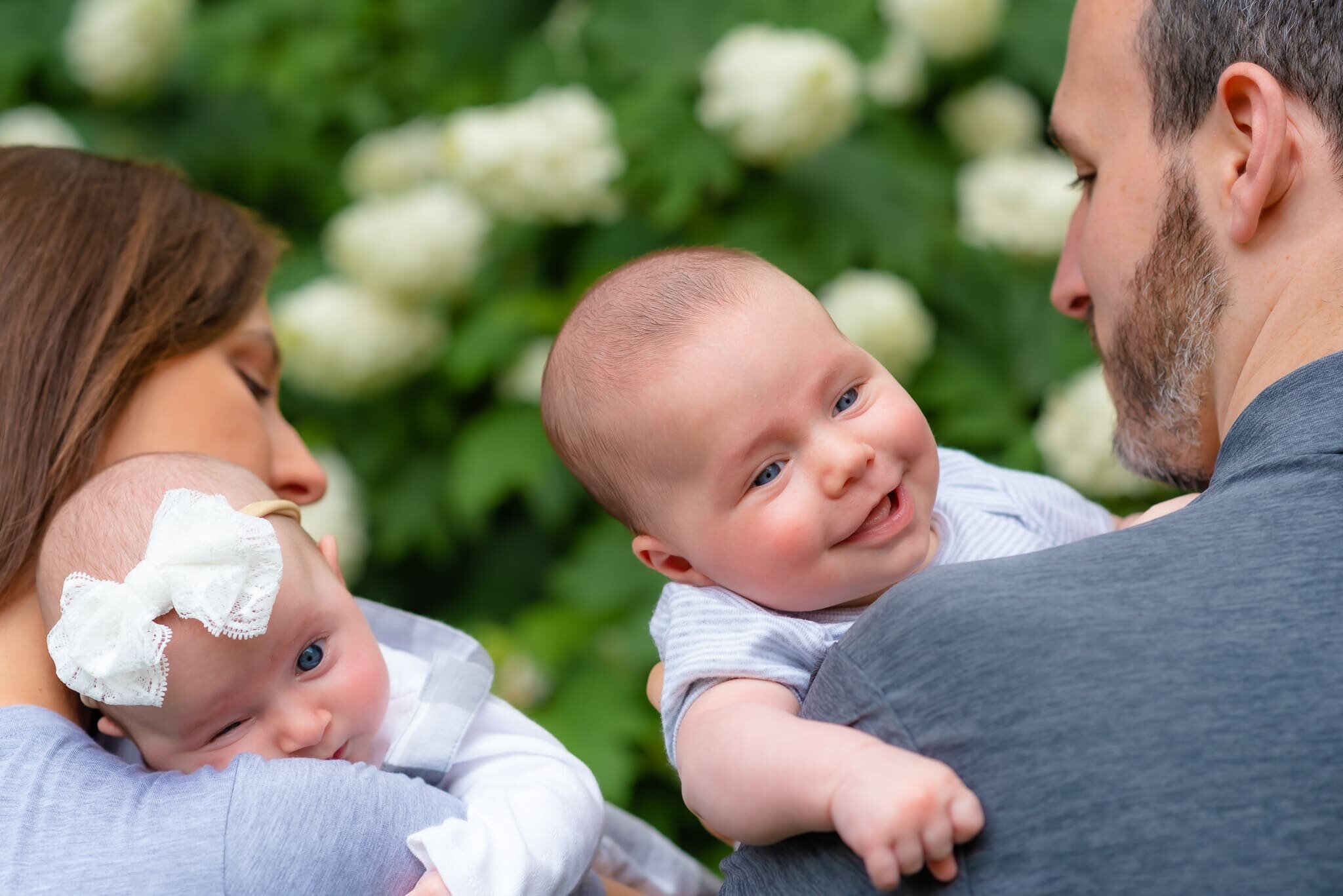 Bethesda Maryland Newborn Photoshoot - smiling baby looking over dad's shoulder