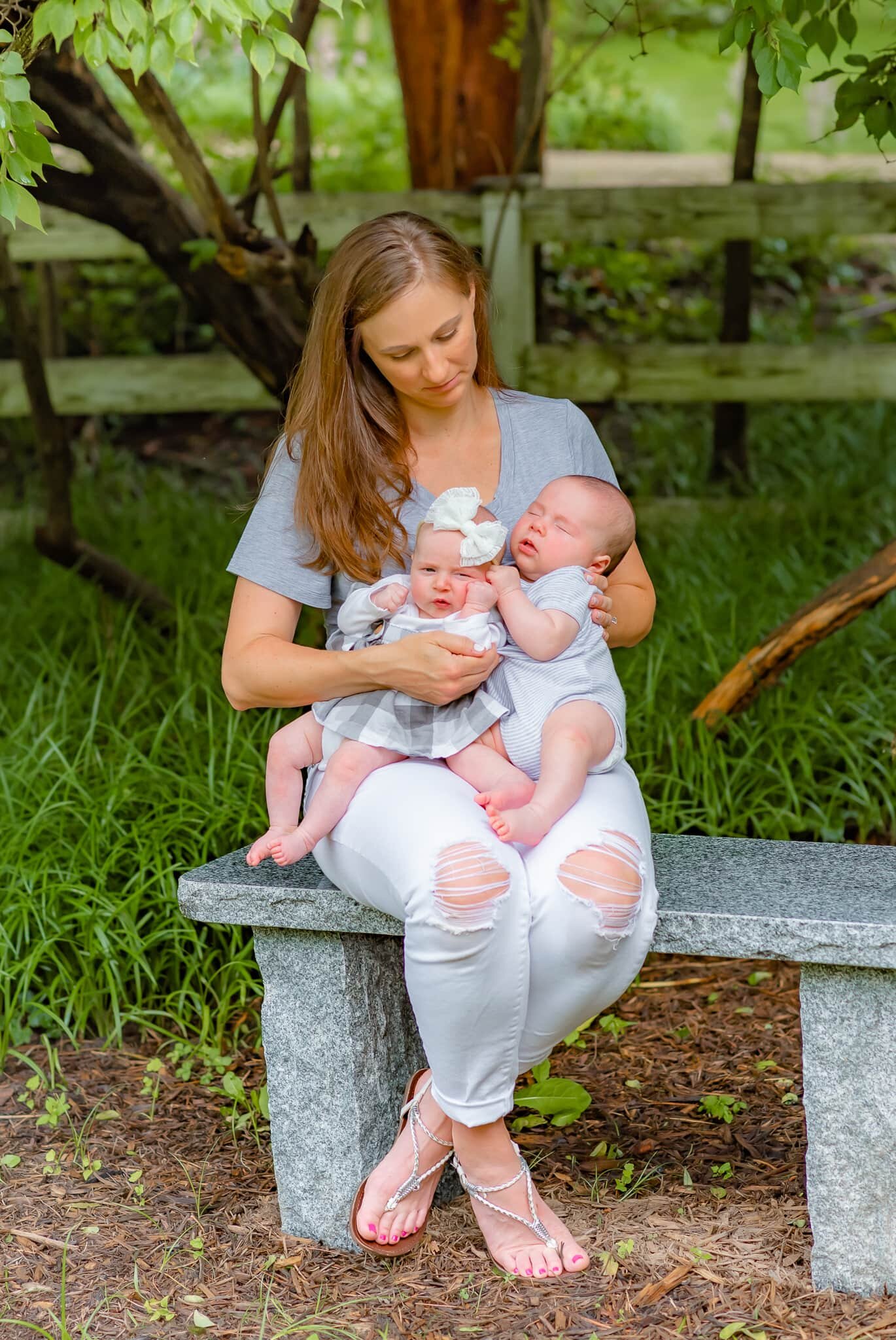 Bethesda Maryland Newborn Photoshoot - mom sitting on a bench holding twins