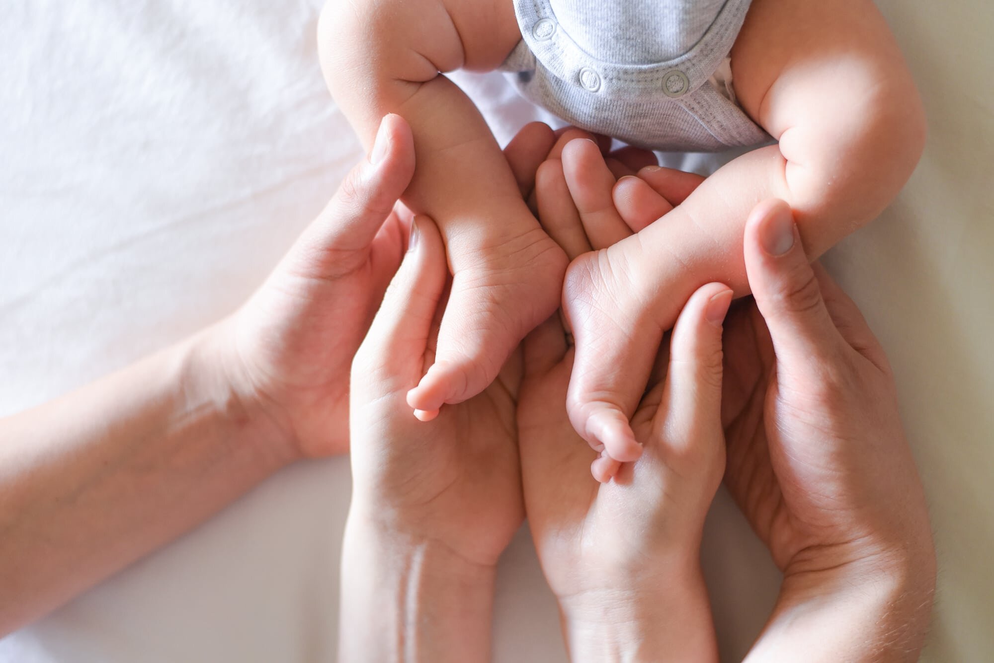 Maryland Newborn Photographer - baby feet cradled in parents hands