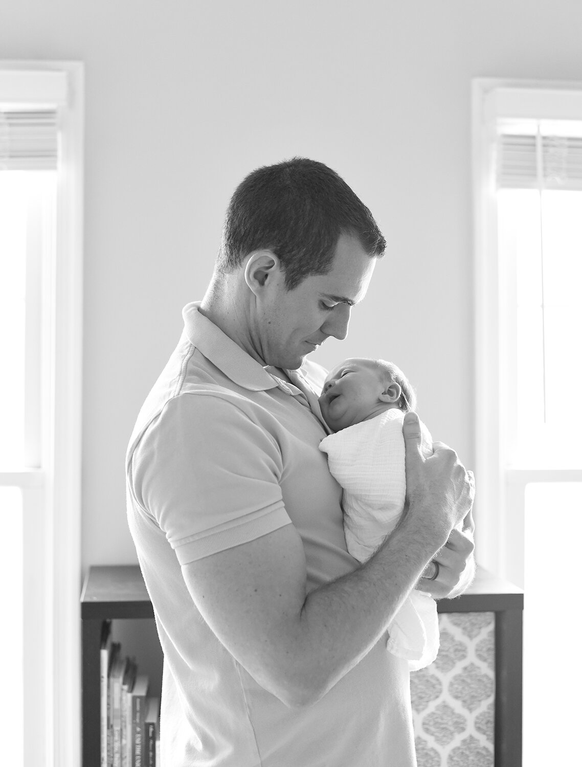 Maryland Newborn Photographer - dad cradling baby on his chest