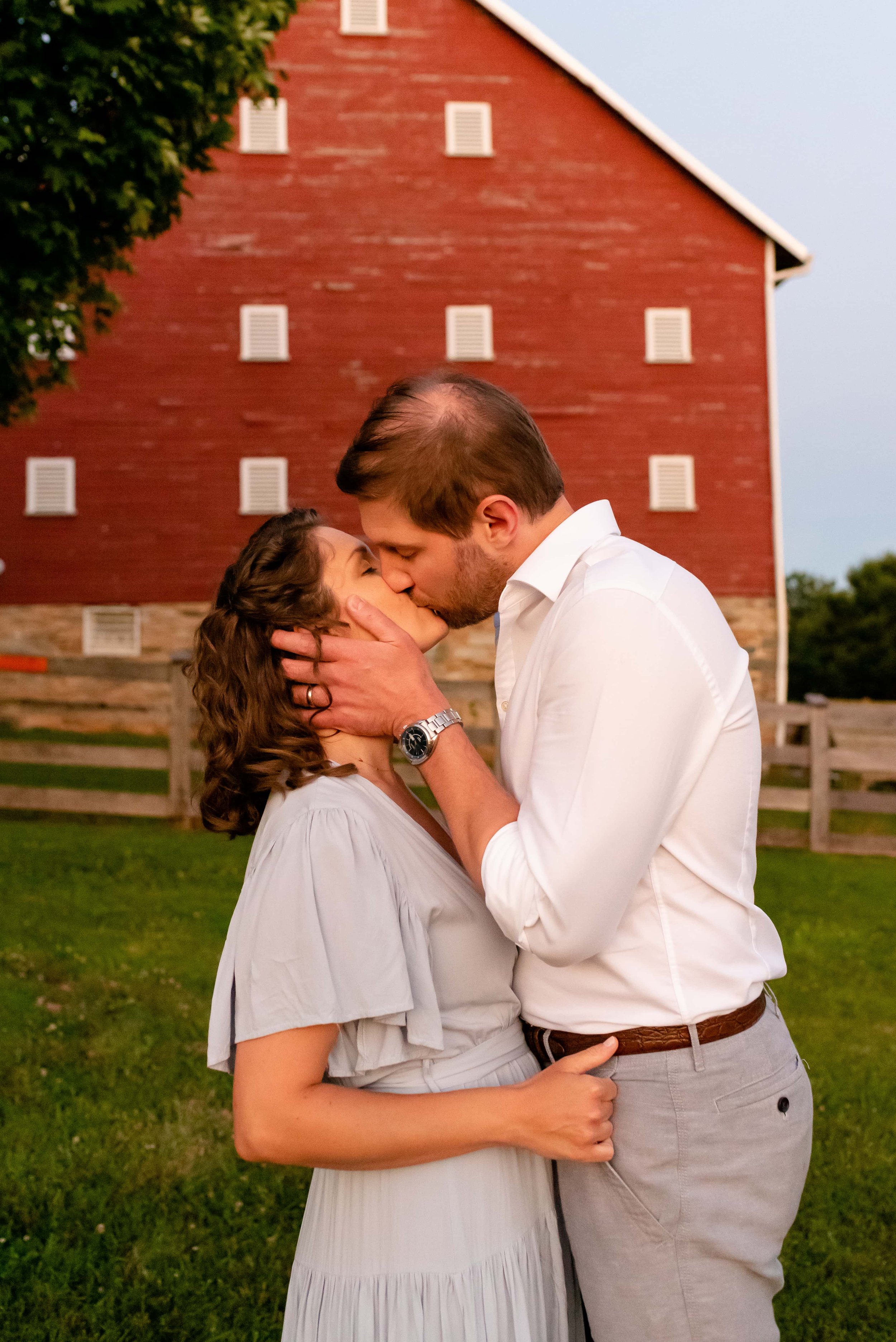 Maryland mom and dad kissing in front of the barn