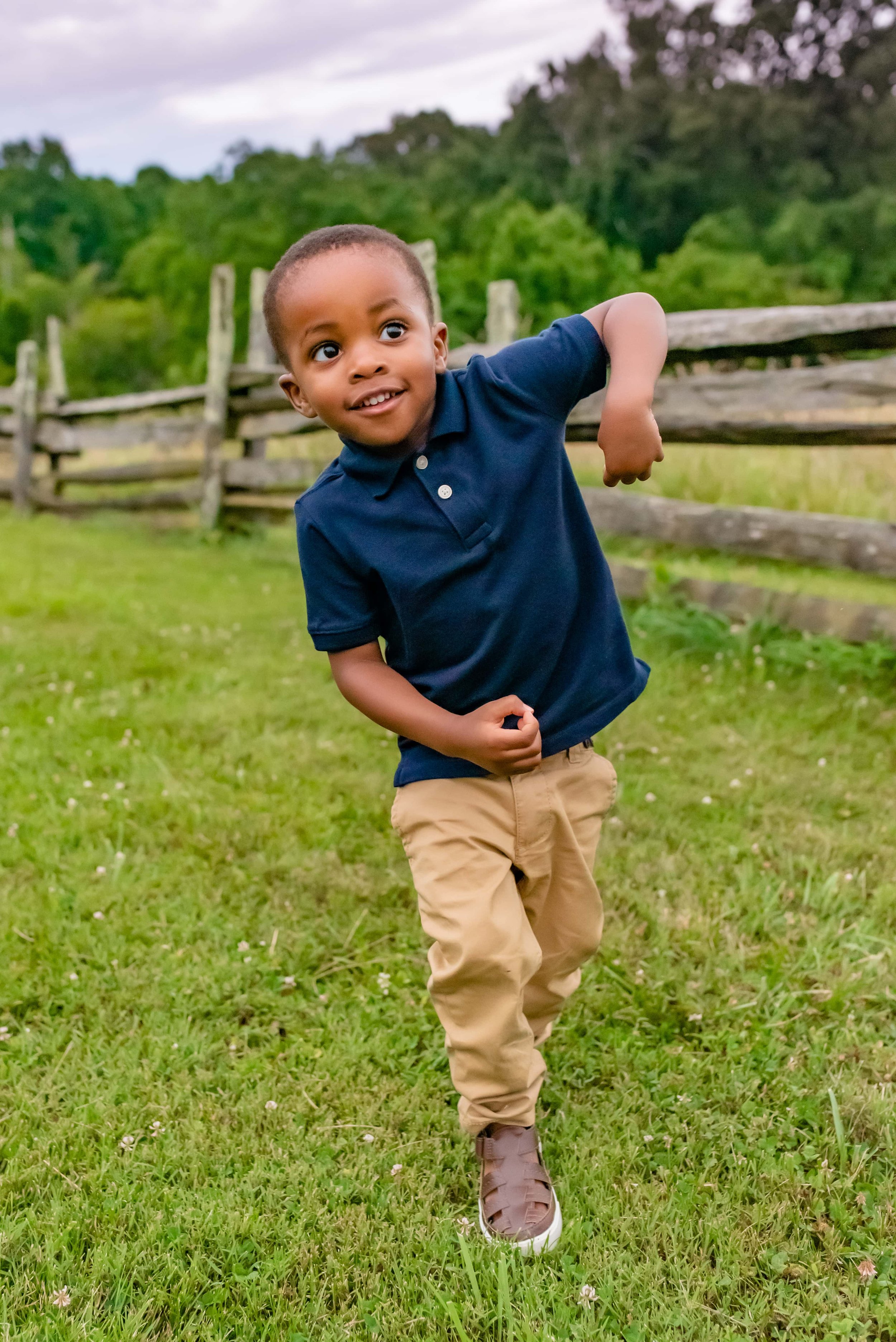 Maryland family photoshoot with little boy dancing by the fence