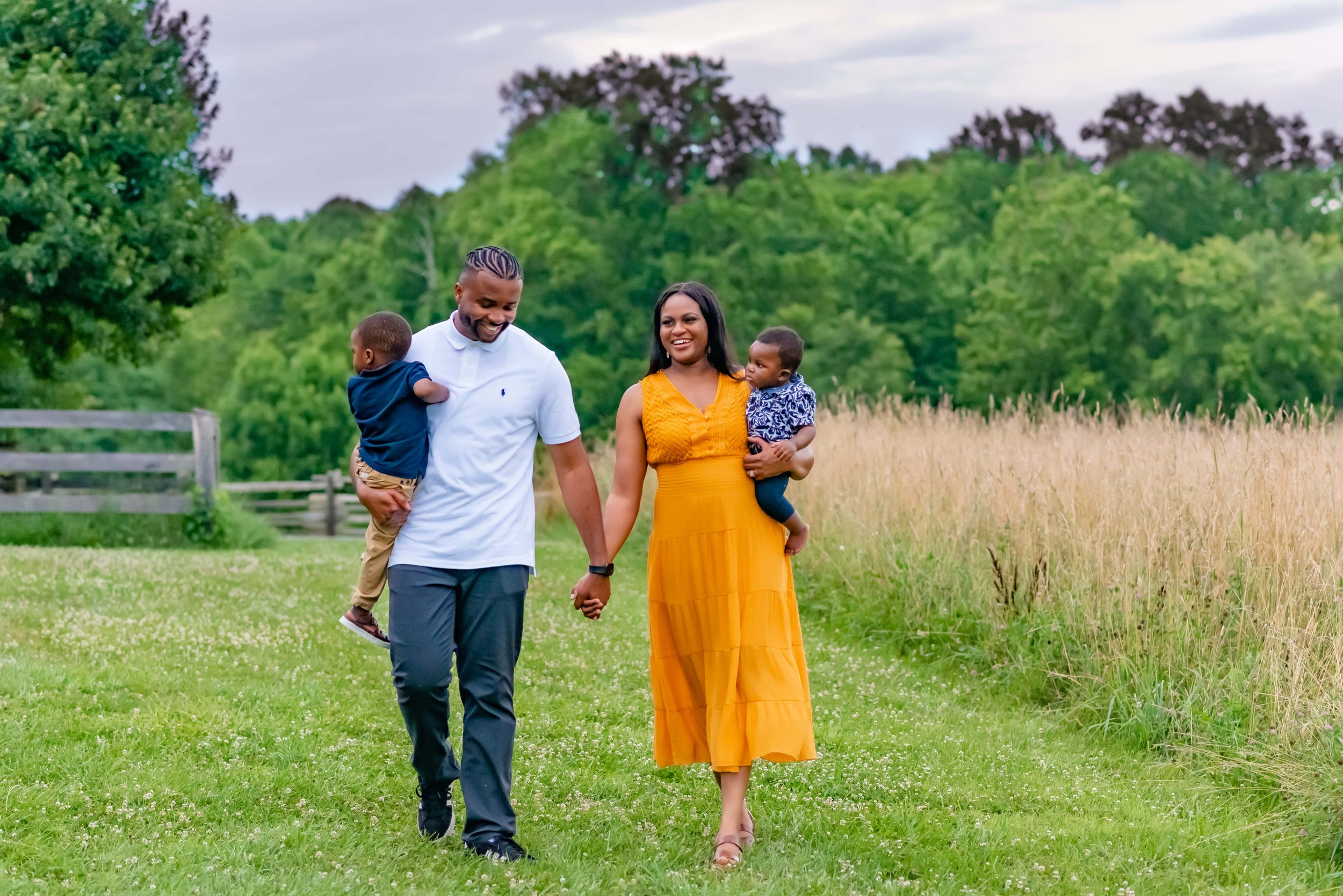 Maryland family photoshoot with family walking through field smiling