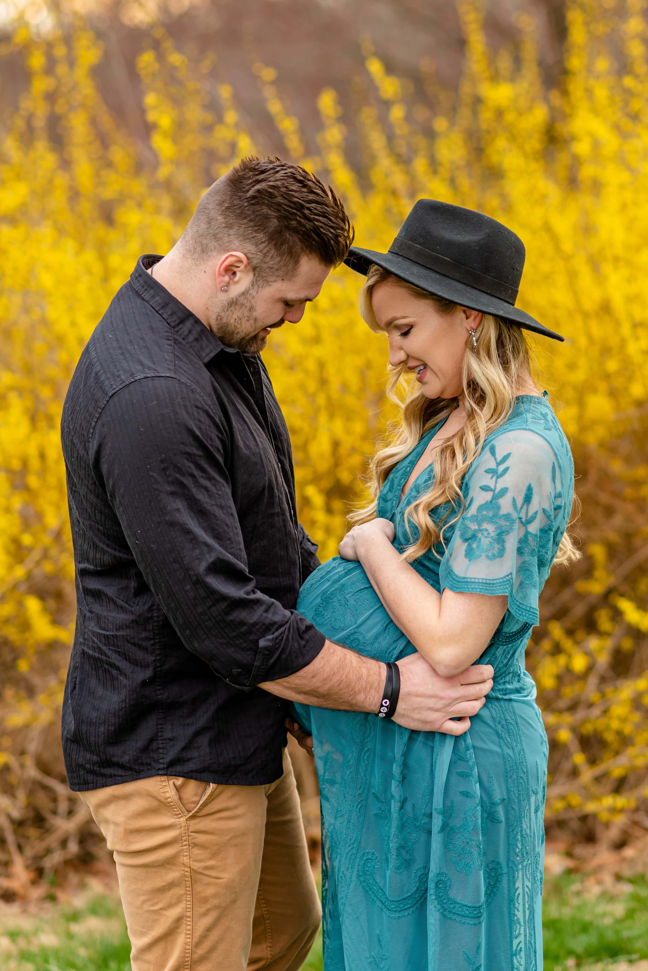 Maryland Maternity Photoshoot with expecting couple looking down at belly