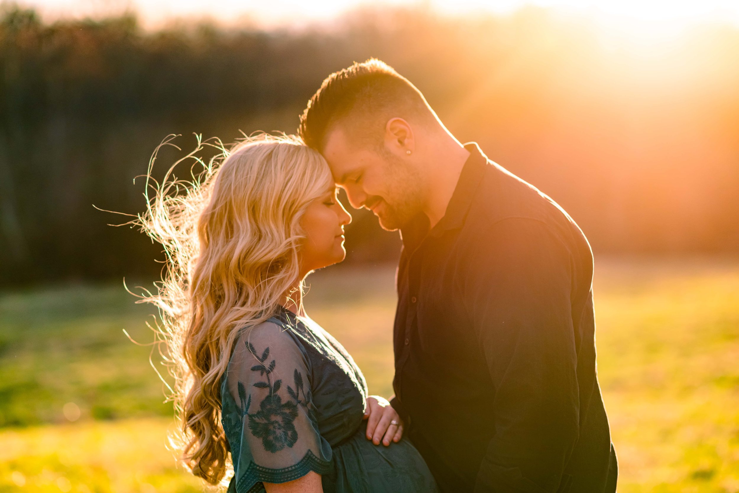 Maryland Maternity photo of couple standing forehead to forehead in a field