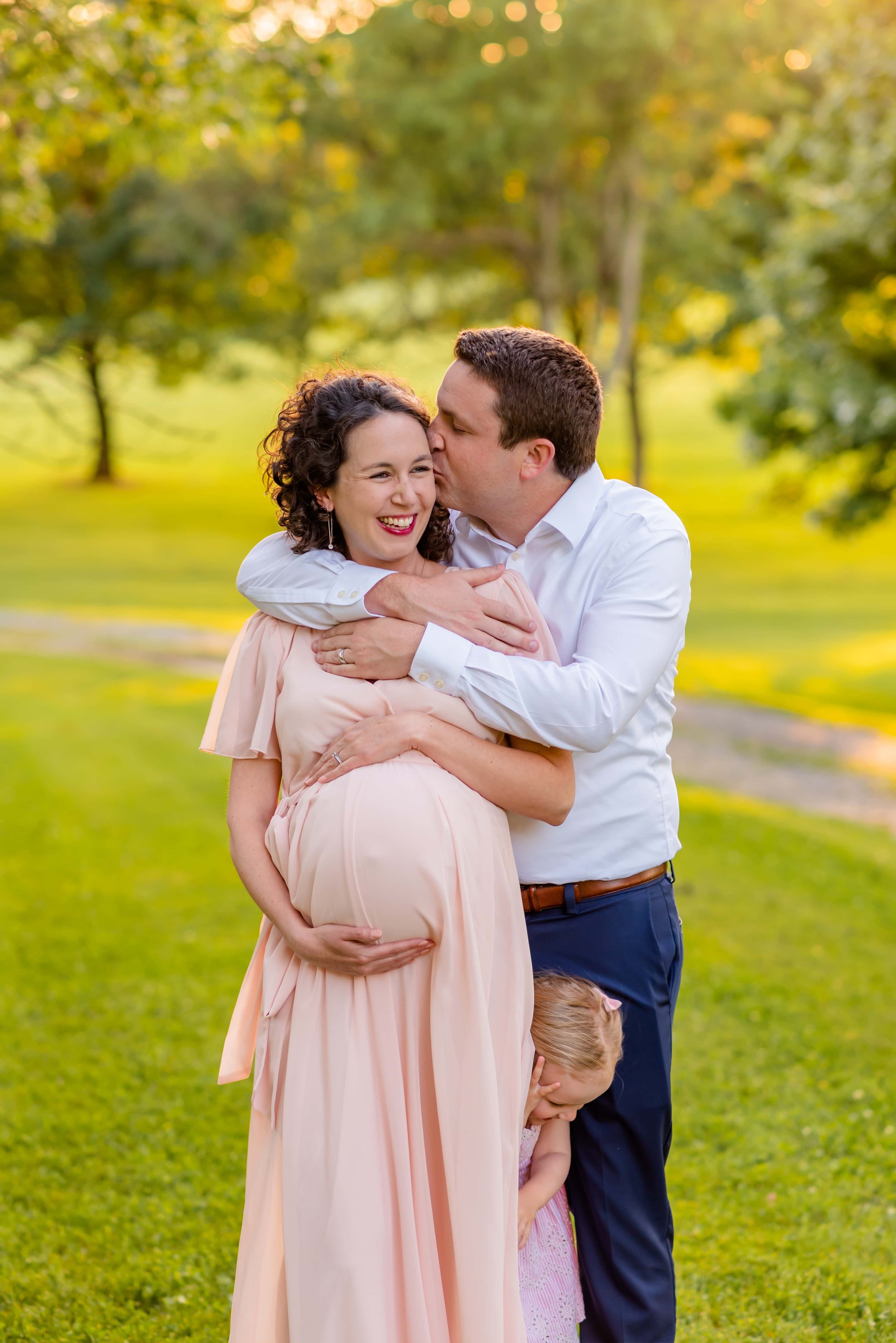 Maternity photo of pregnant woman being kissed by her husband