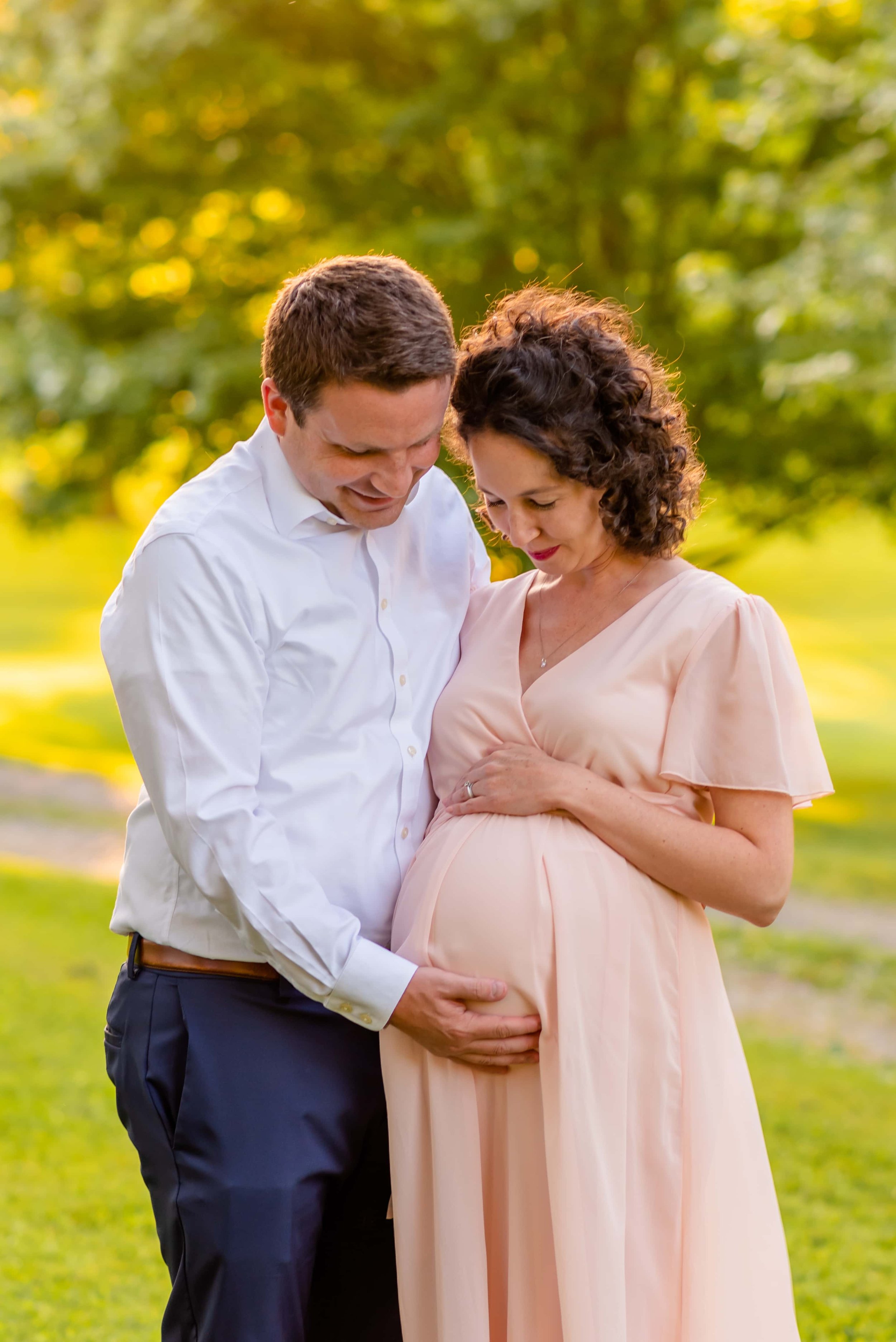 Maryland Maternity Photo of Man and Woman Holding and Looking Down at Her Belly
