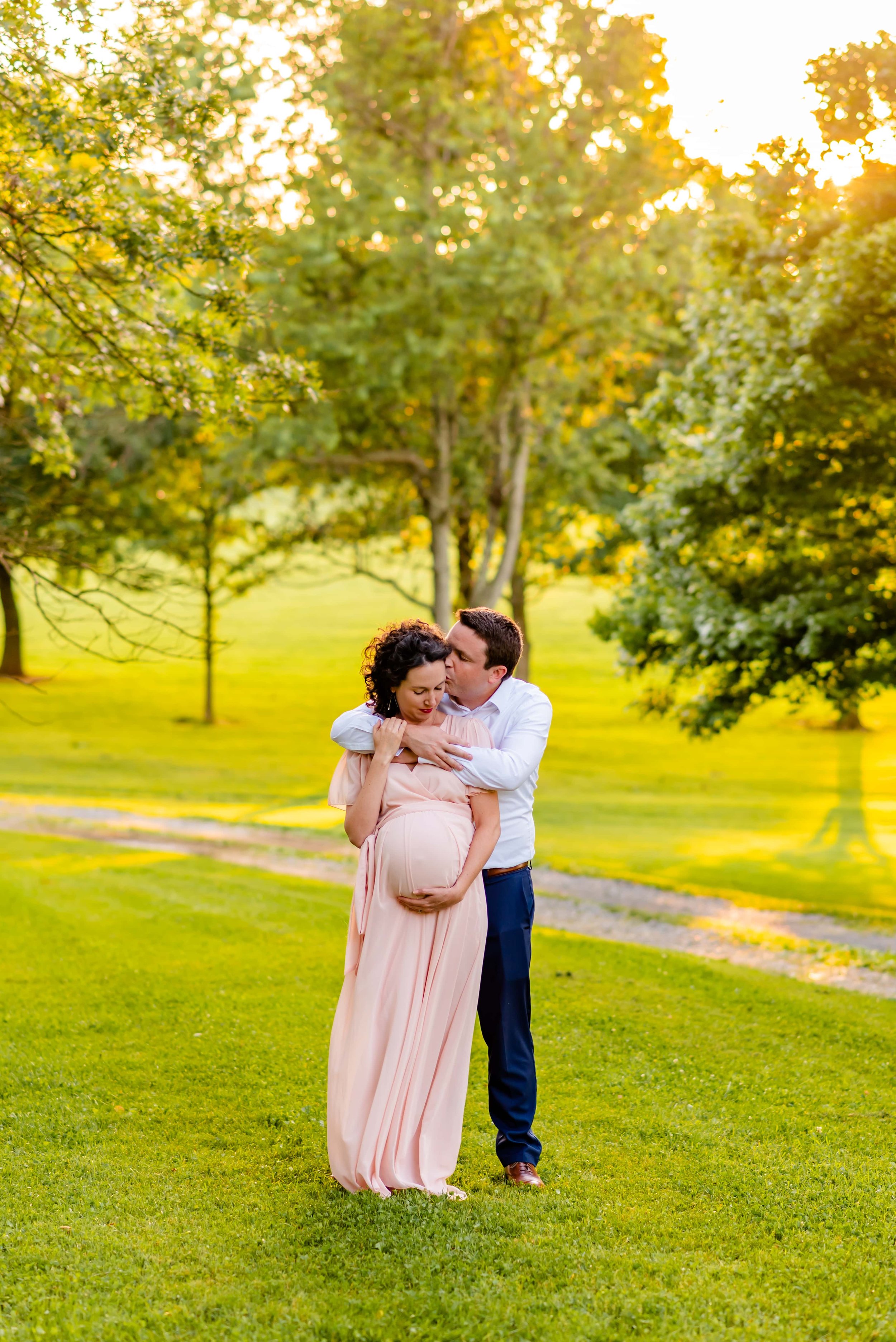 Maryland Maternity Photo of Man and Woman at Sunset both holding onto her belly