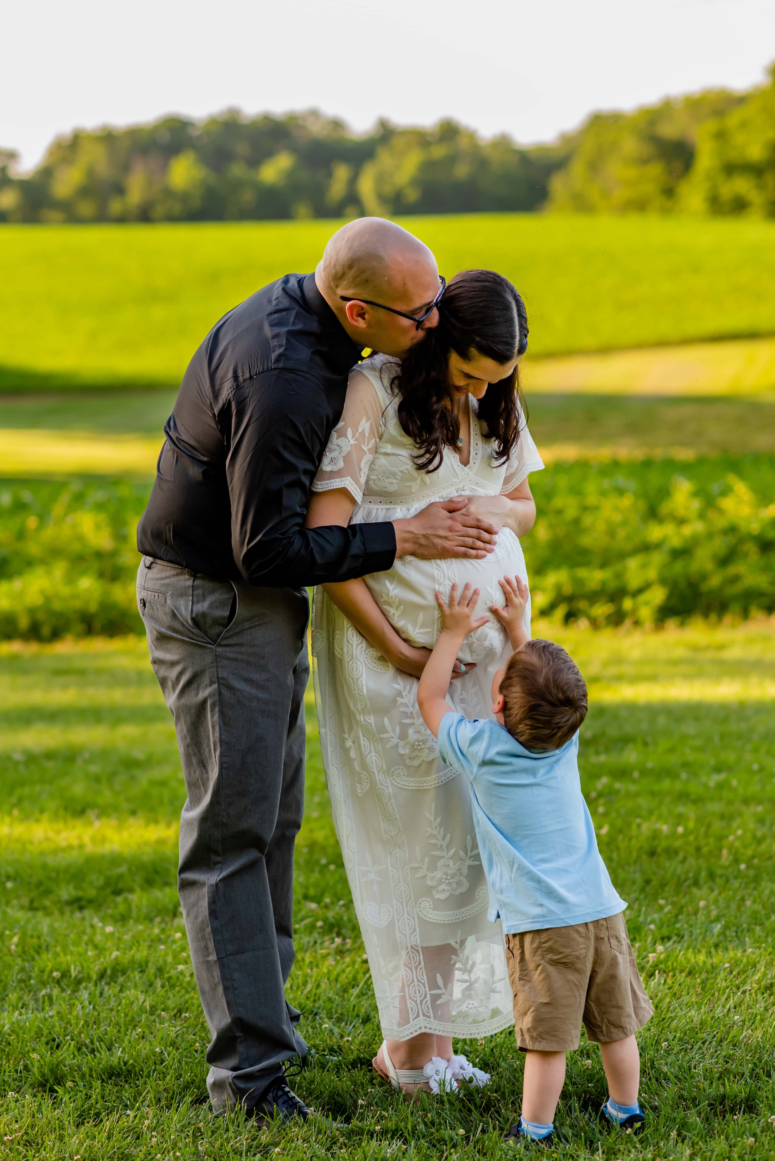 Maryland Maternity photos of mom, dad and toddler feeling mommy's belly