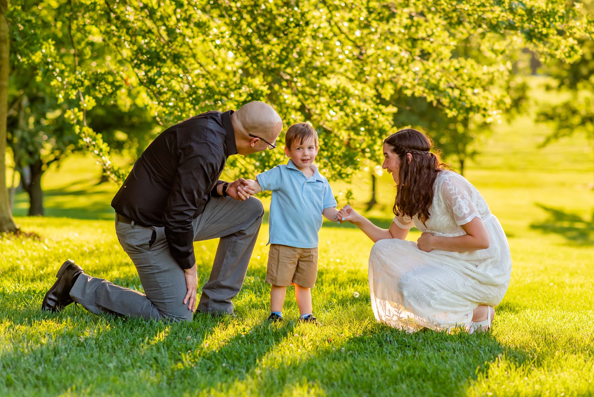 Maryland Maternity photos of mom, dad and toddler kneeling in a park