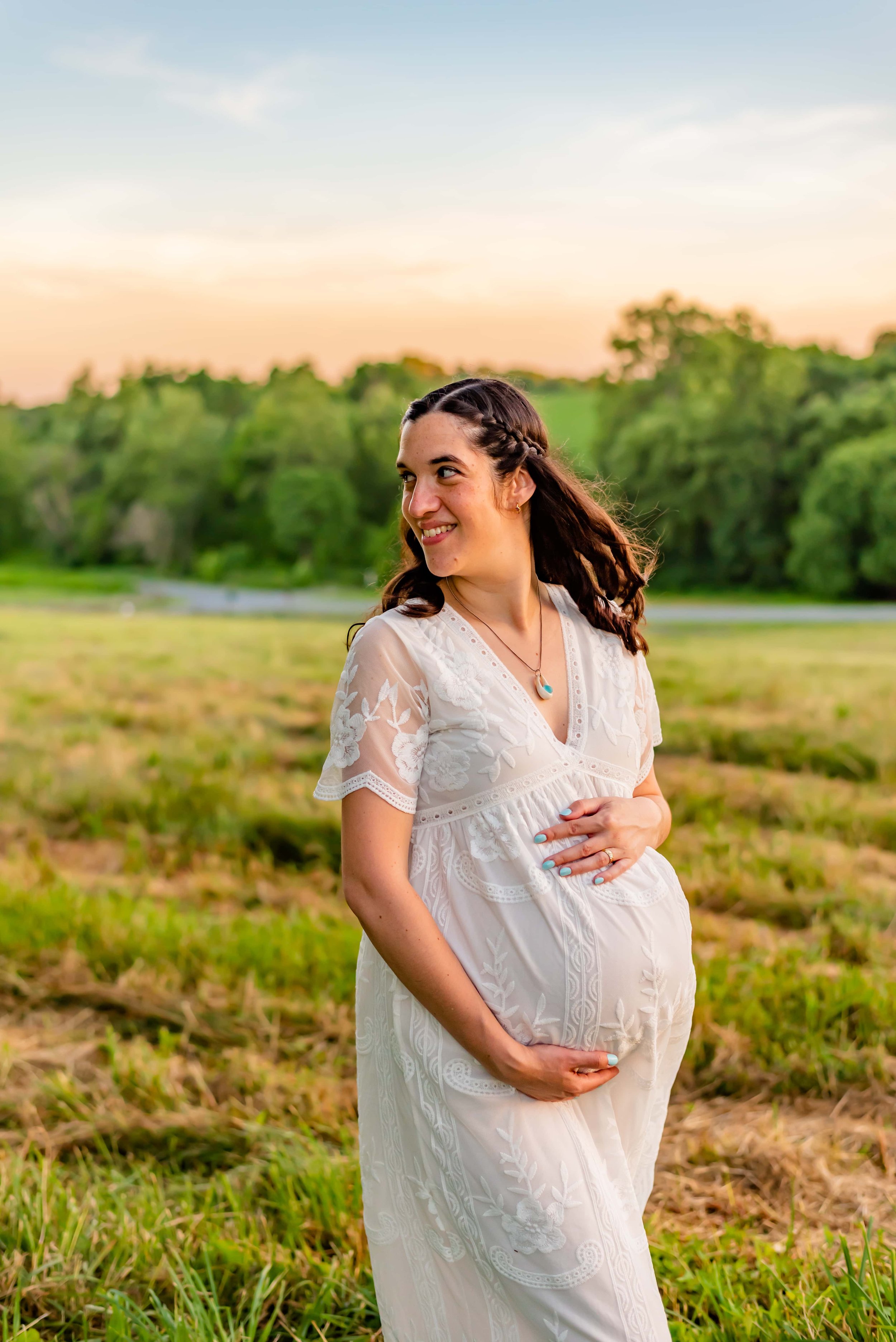 Maternity photo of woman in Maryland standing in a field looking over her shoulder