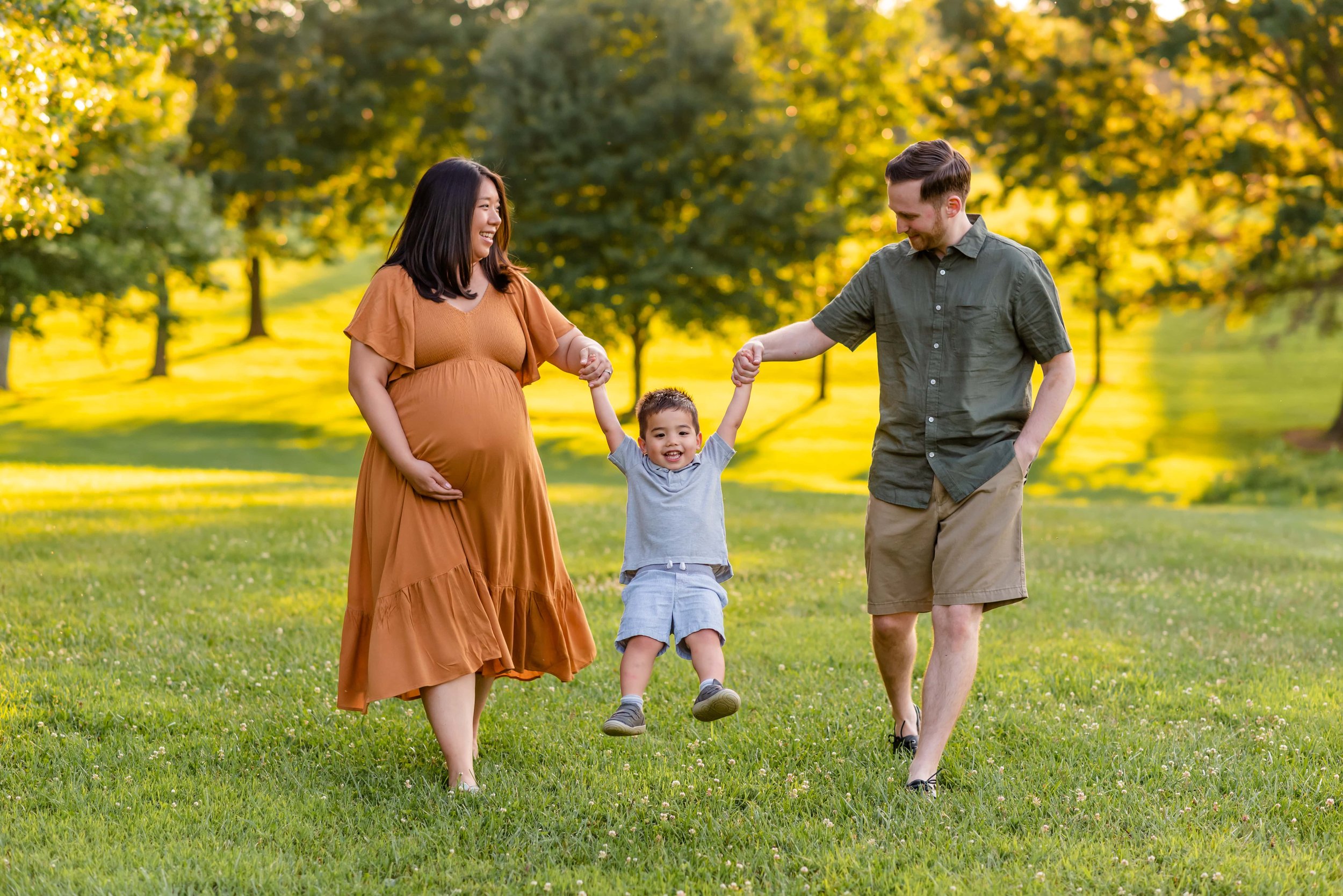 Maryland Summer Maternity Photos of mom, dad and toddler being swung by parents