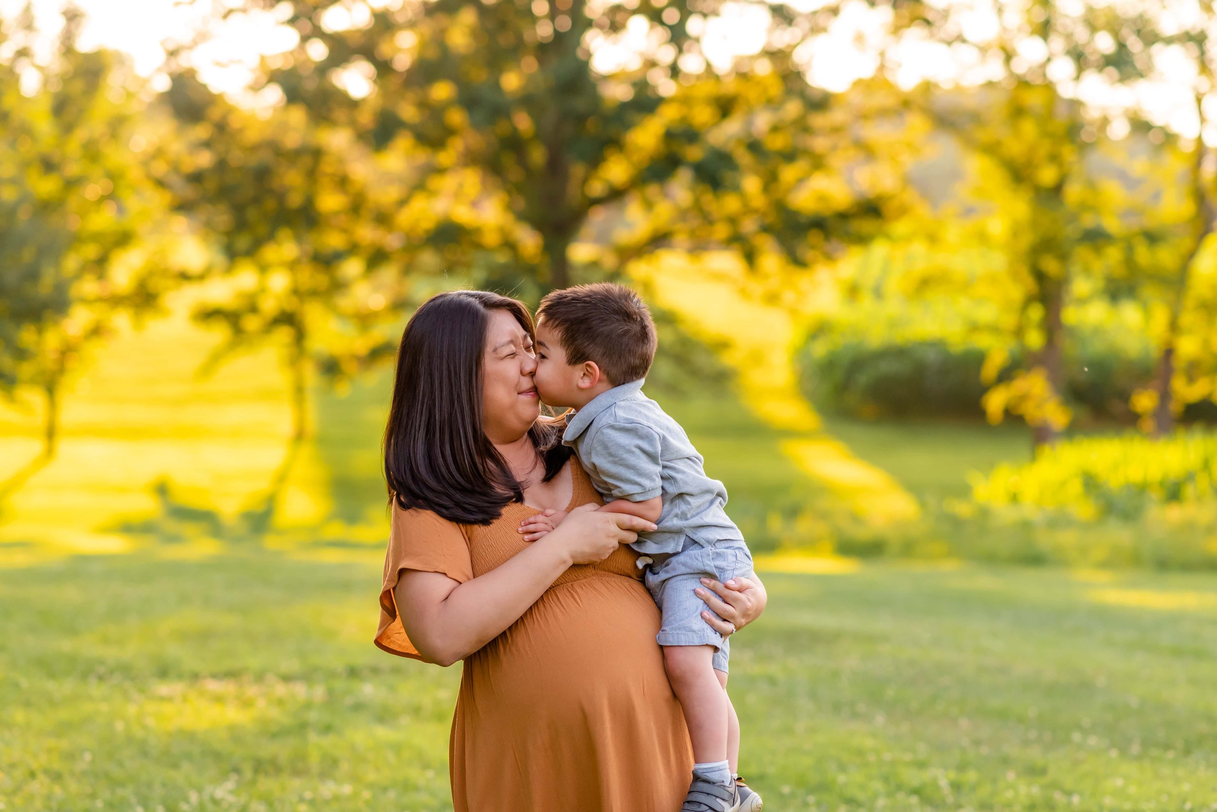 Maryland summer maternity photos with mom and son laughing together in a field
