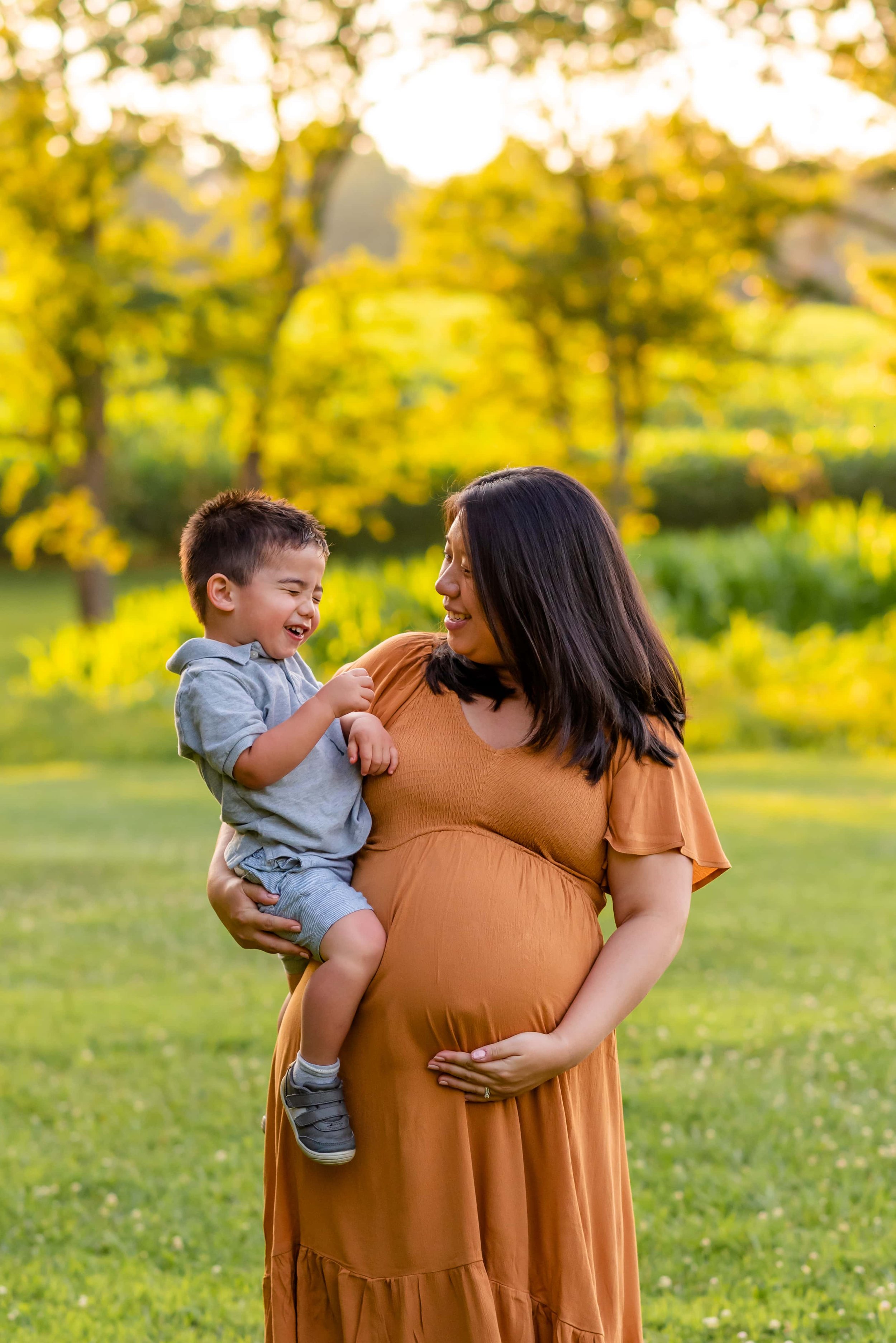 Maryland summer maternity photos with mom and son laughing together